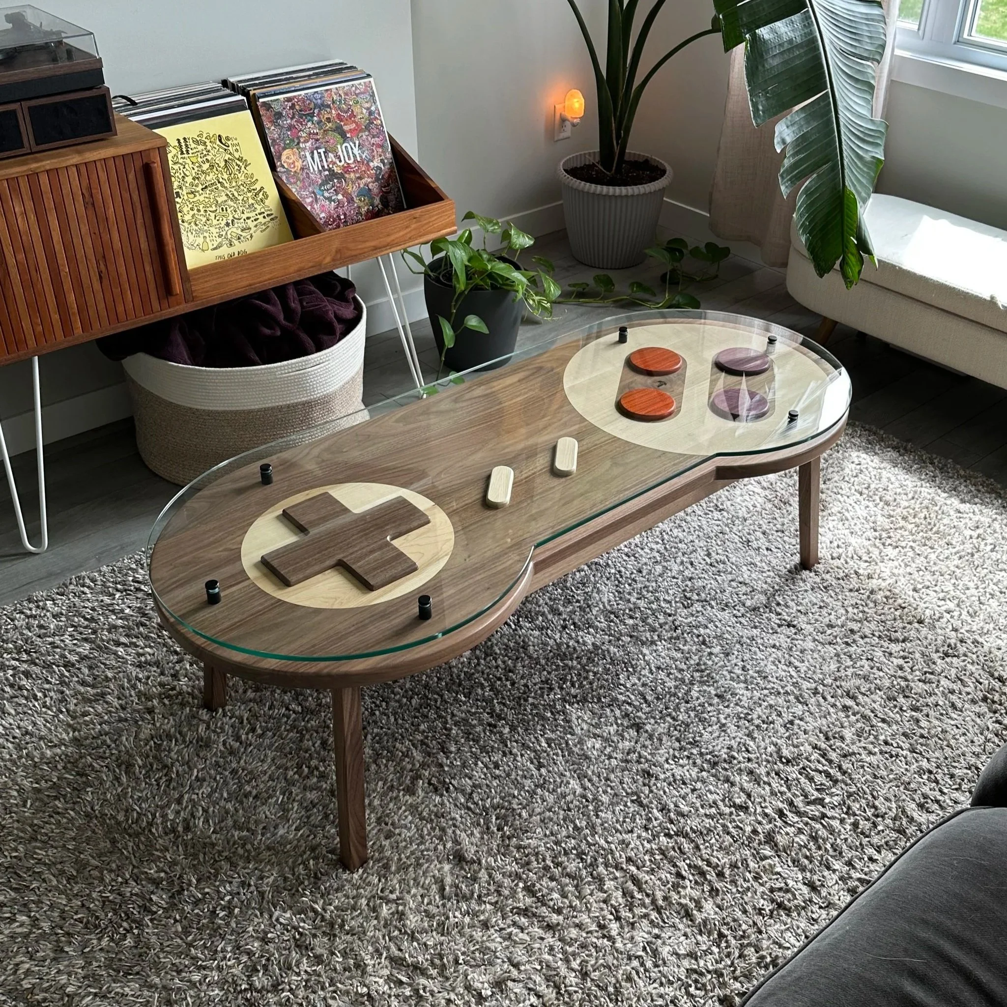 View from the corner of a wooden version of a SNES controller with a glass top and raised buttons