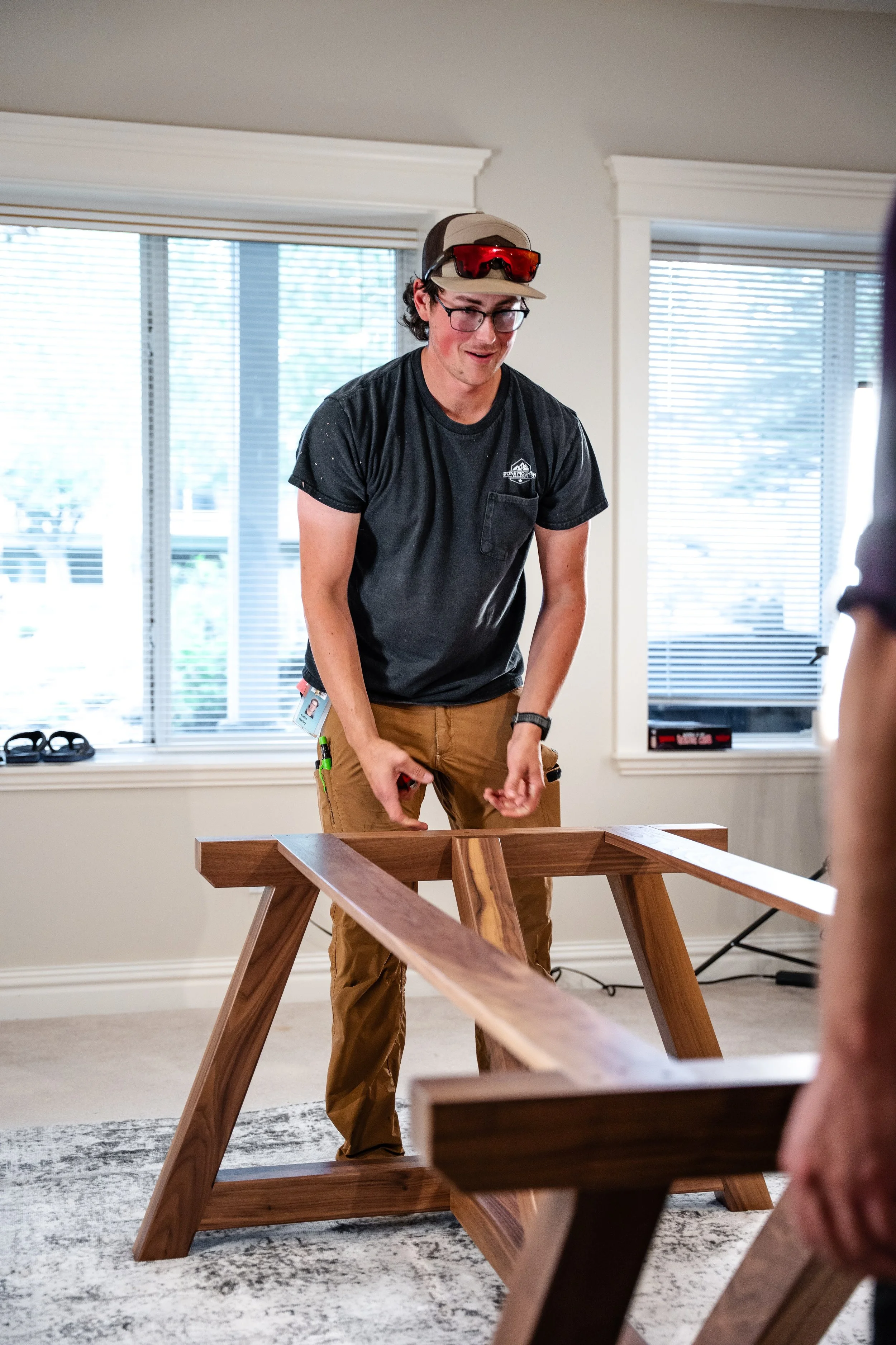 Harley Griffin in a black t shirt moving a table base into position