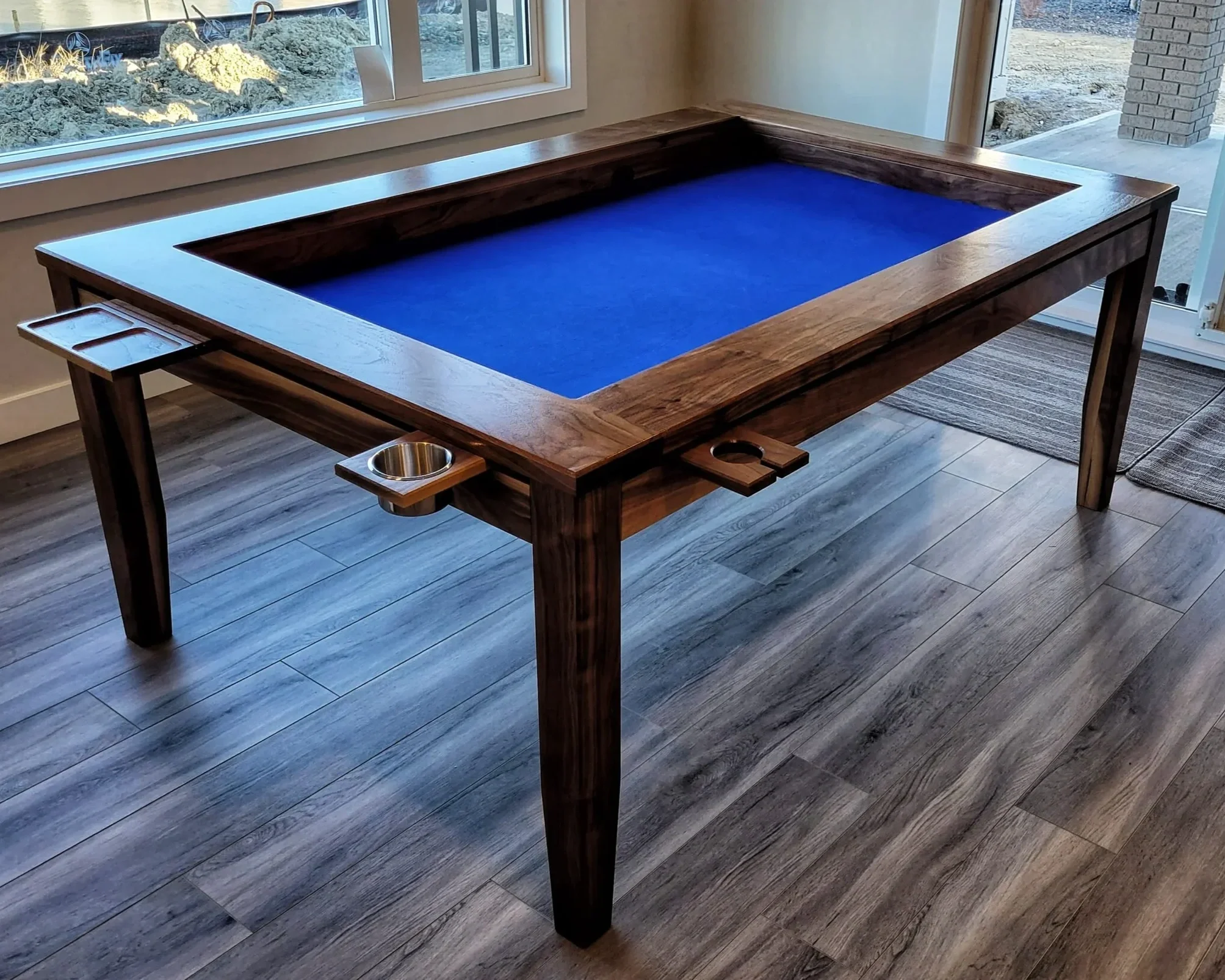 view from the corner of a walnut game table with 4 post legs and accessories attached to the tables edge