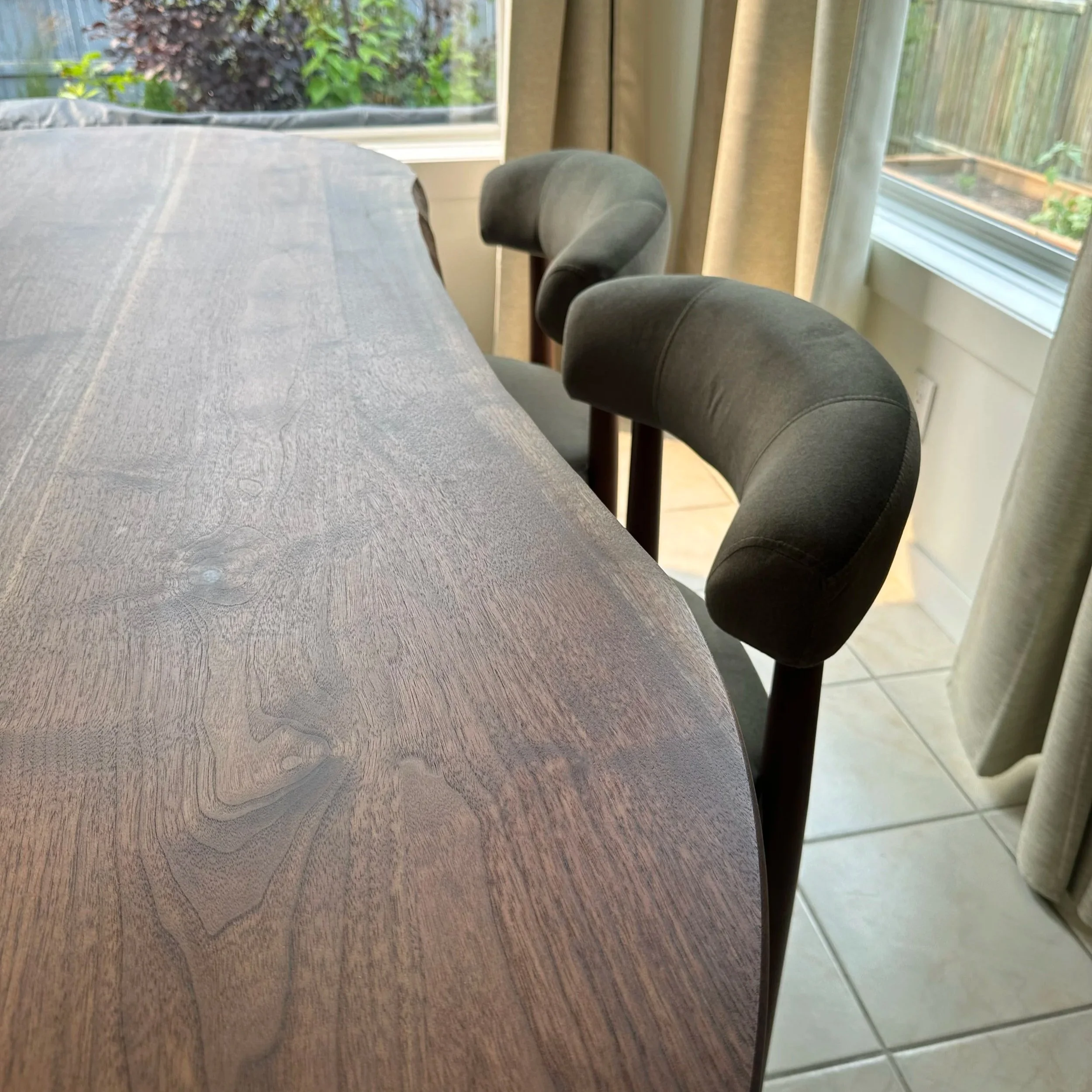 close up view of the live edge and green dining chairs