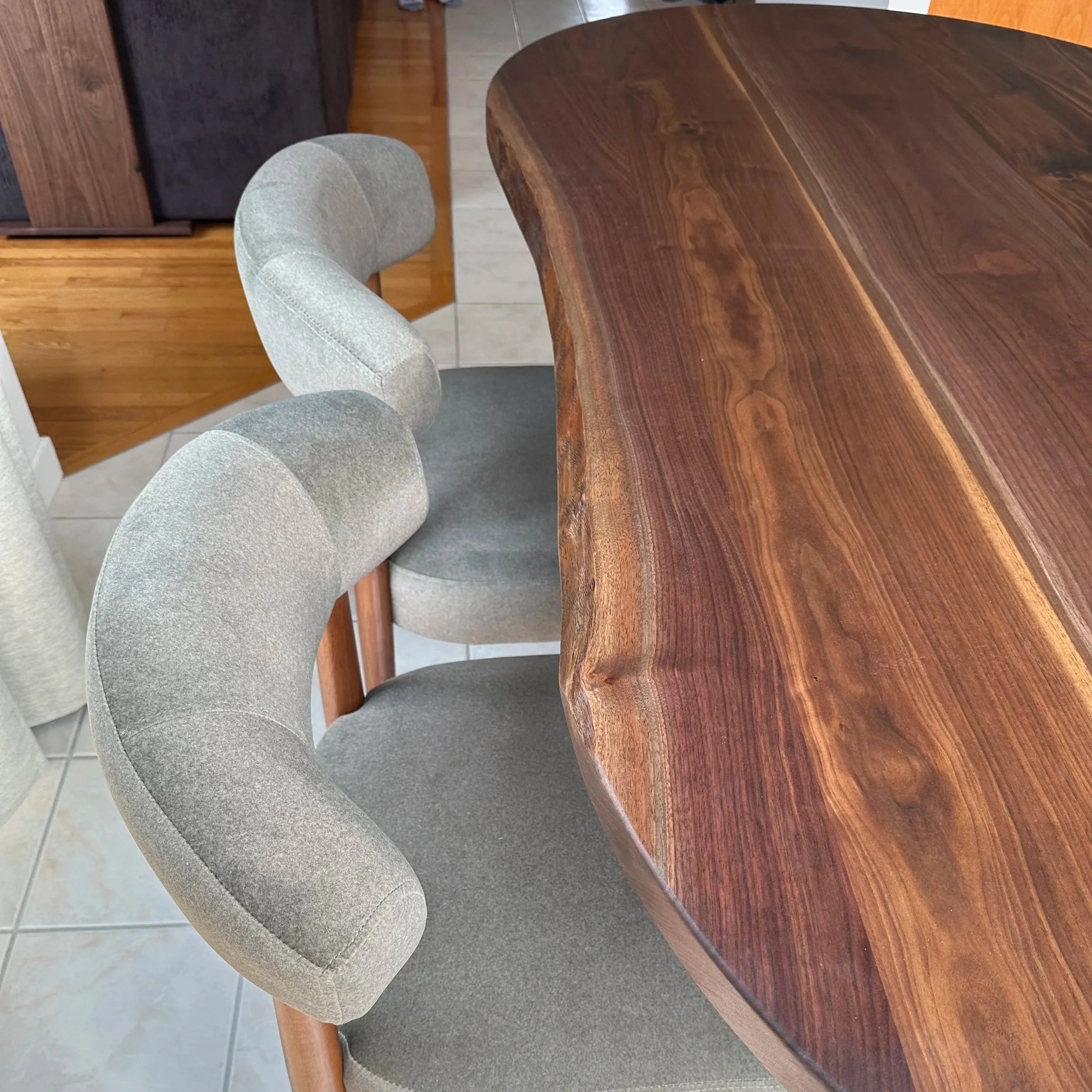 Close up view of green chairs and the live edge used on the dining table