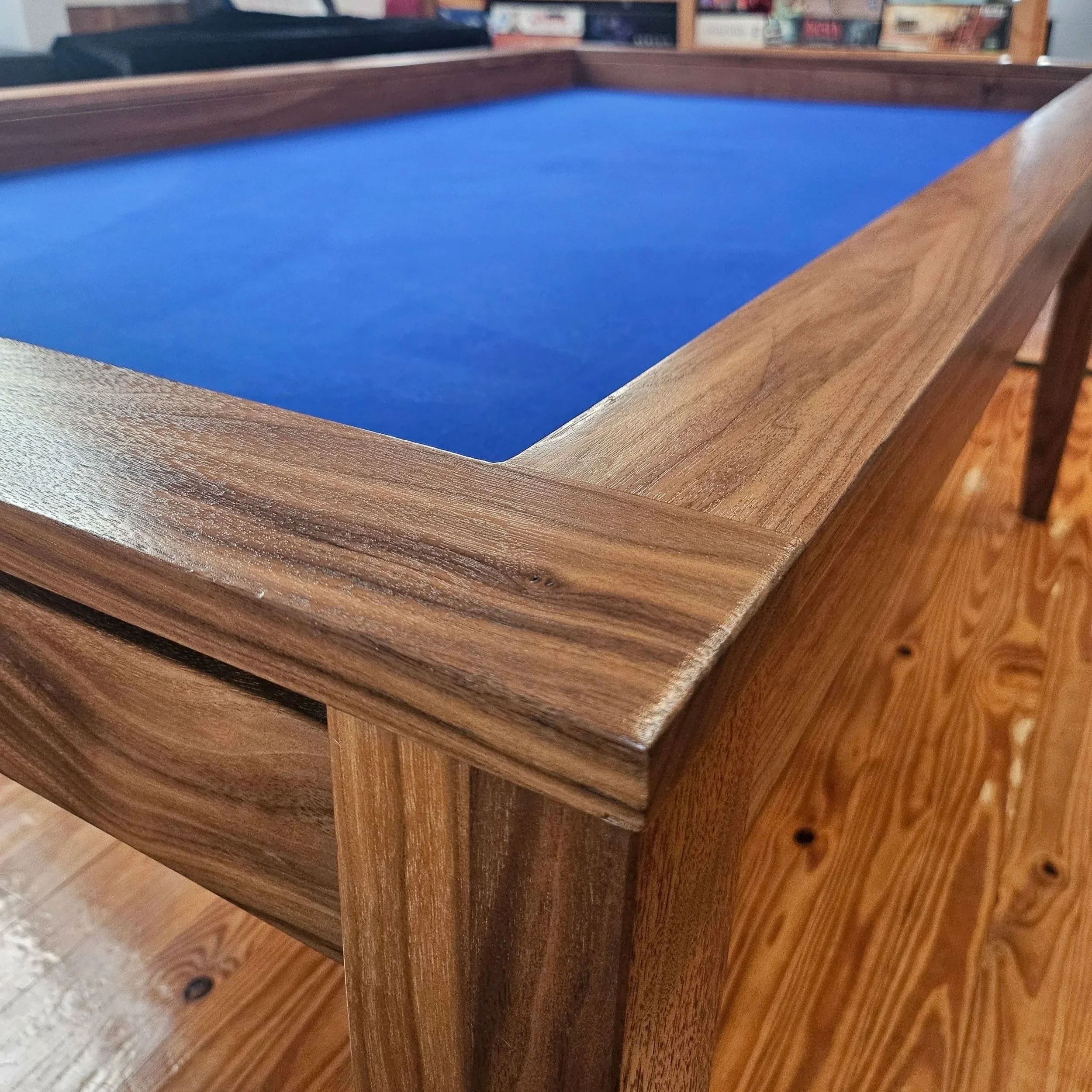 Close up view of the corner of a custom walnut game table showcasing the grain of the wood
