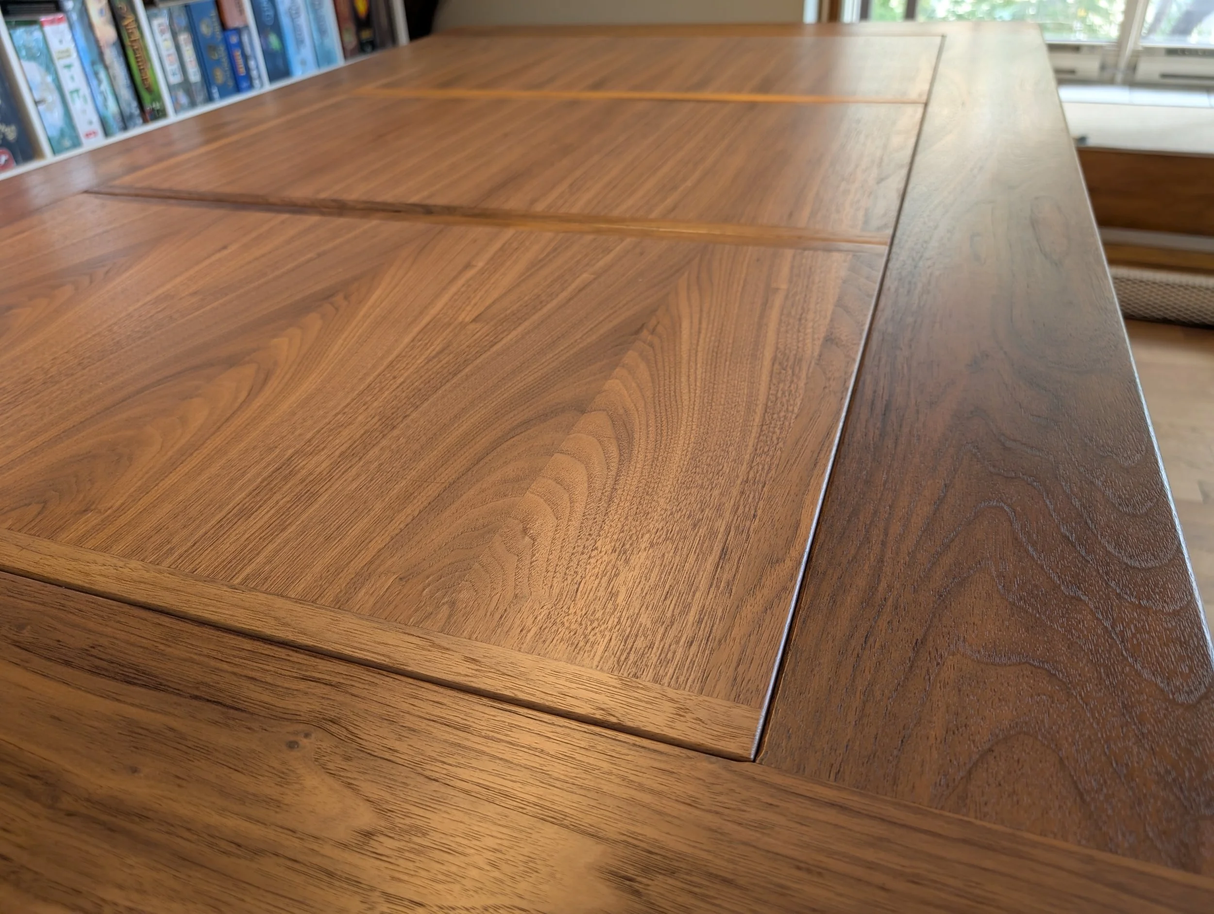 Detail of the walnut tabletop showing the recessed tabletop panel with solid wood edging