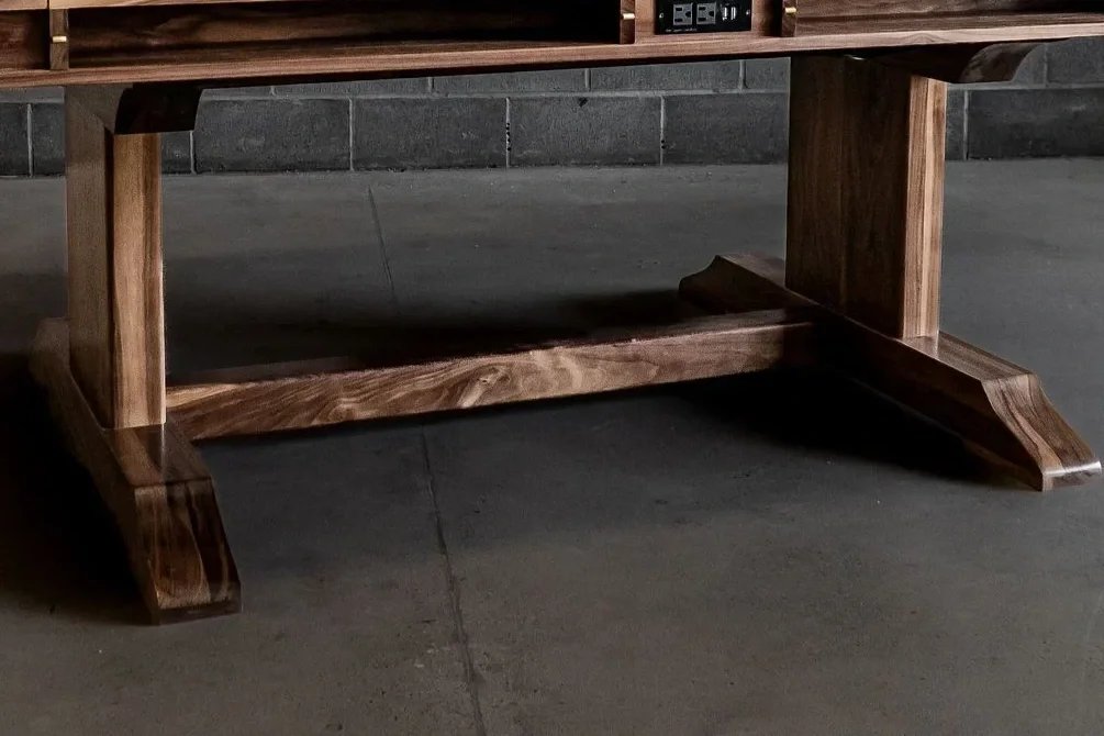 Clsoe up view of a  trestle table base crafted in walnut