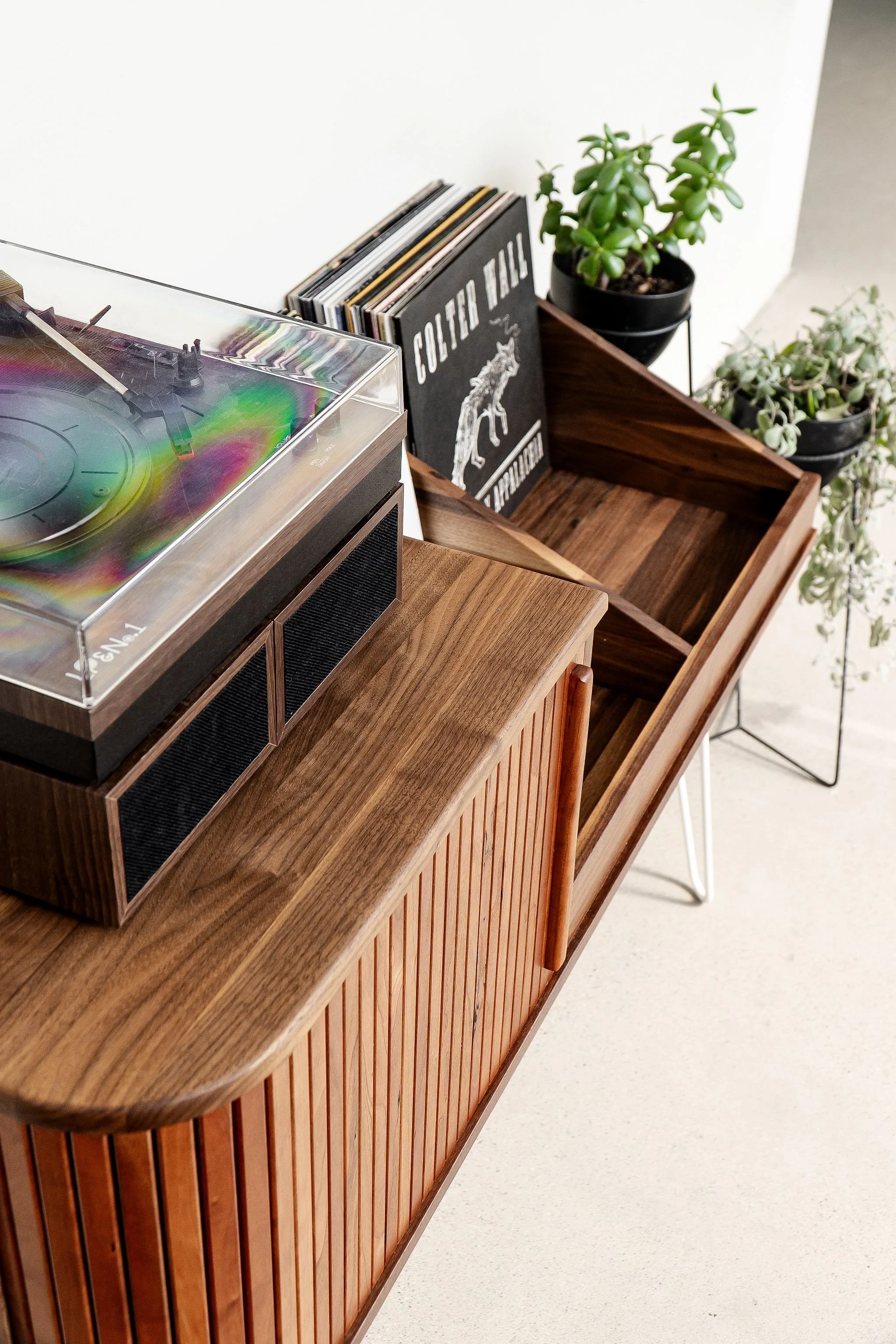Walnut and cherry record cabinet with cherry tambour door and two open storage bays for records and a large top surface with a record player placed on it