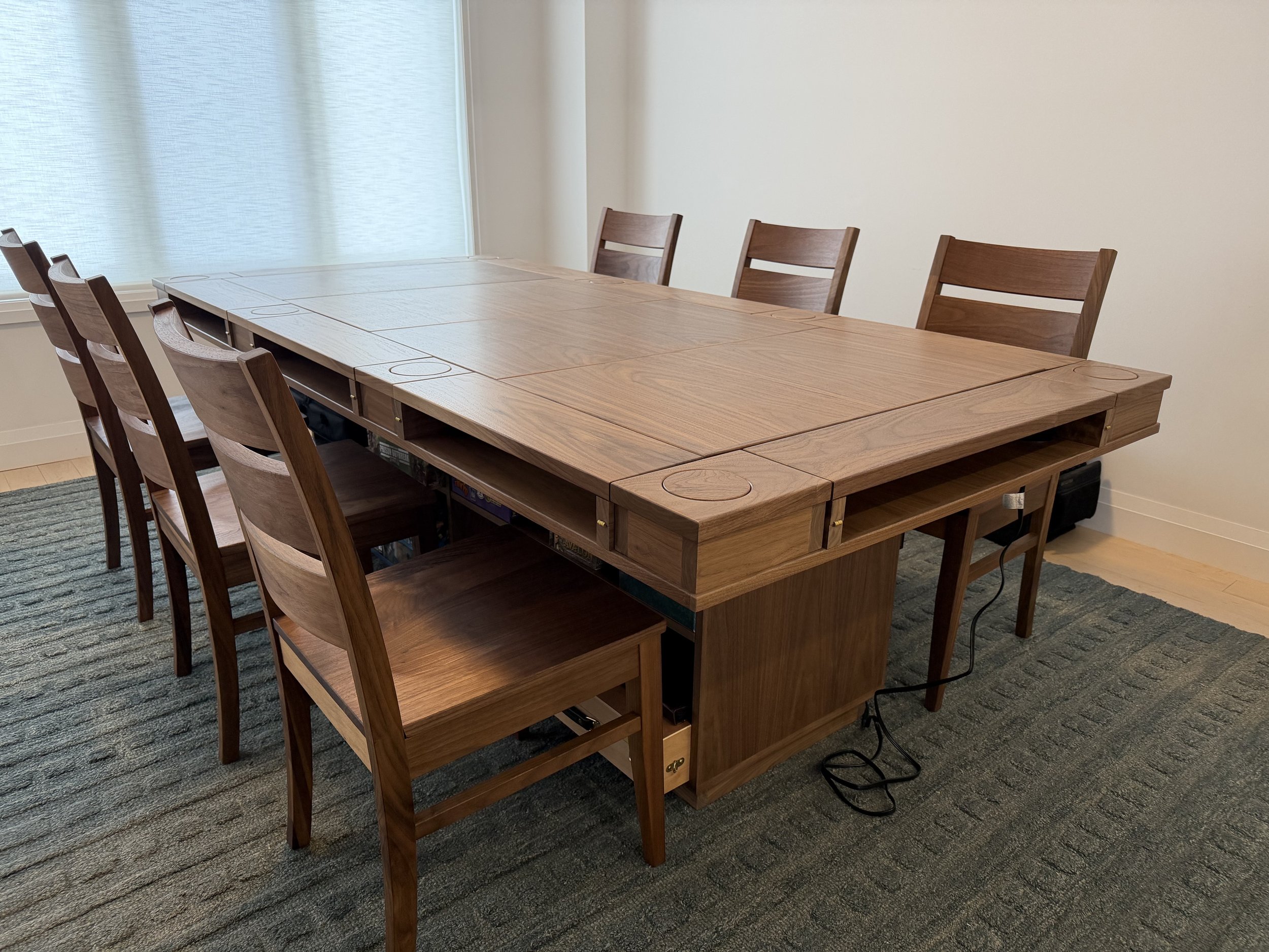 Corner view of a Player station game table with walnut chairs placed around it
