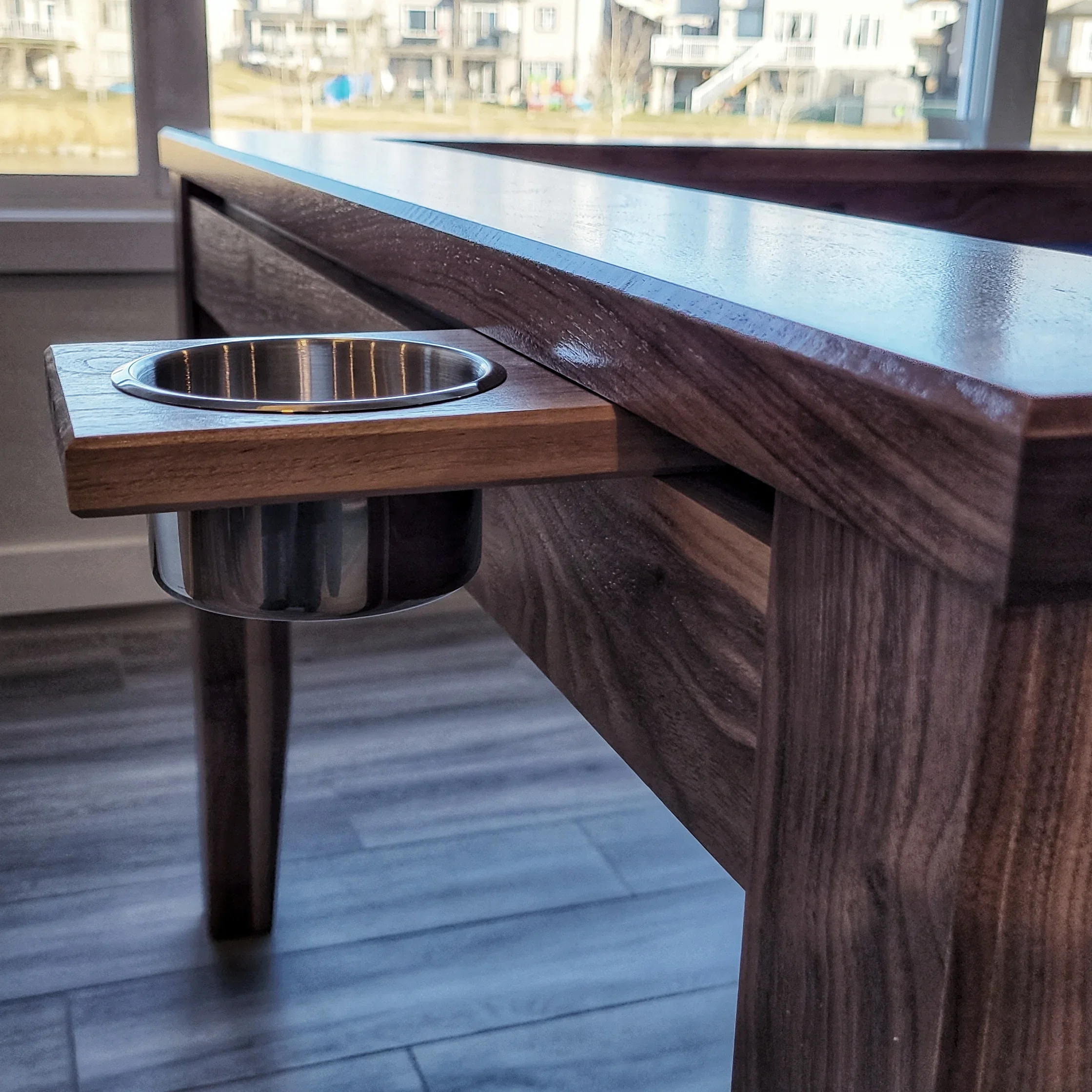 Close up view of a cup holder accessory clipped onto the magnetic game rail built and designed by Stone Mountain Projects in Calgary Alberta