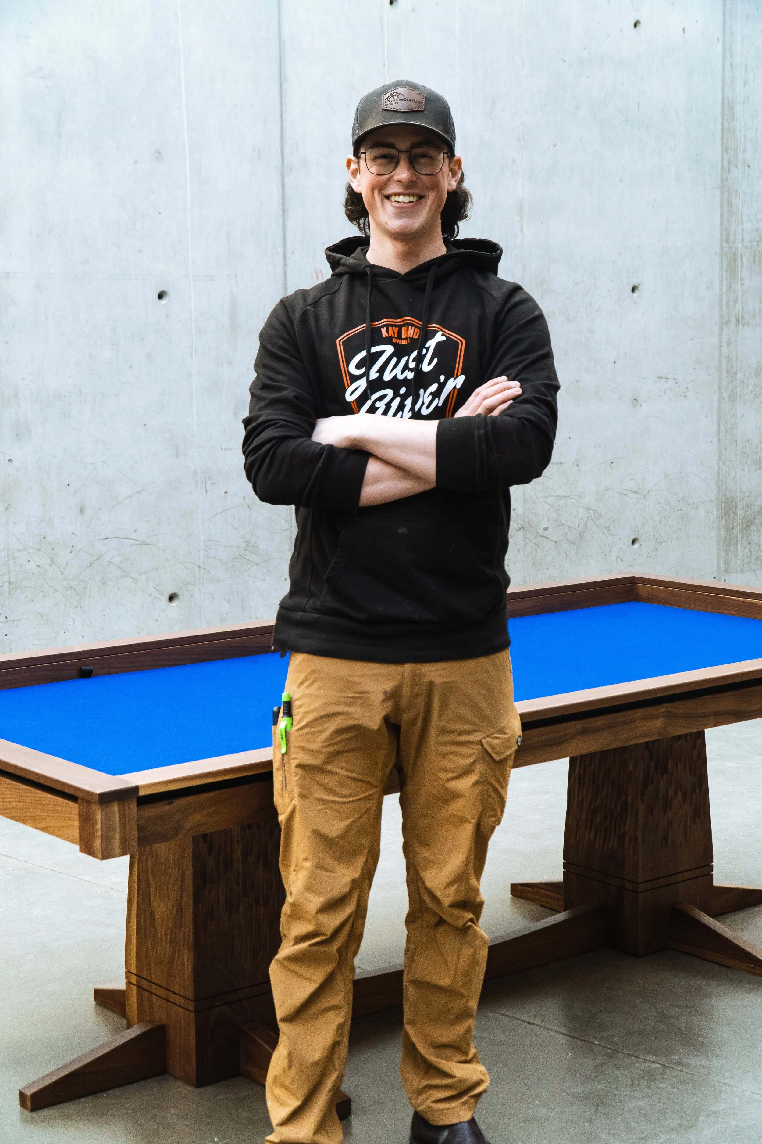 Portrait of Harley Griffin owner of Stone Mountain Projects posing in front of one of his custom tables