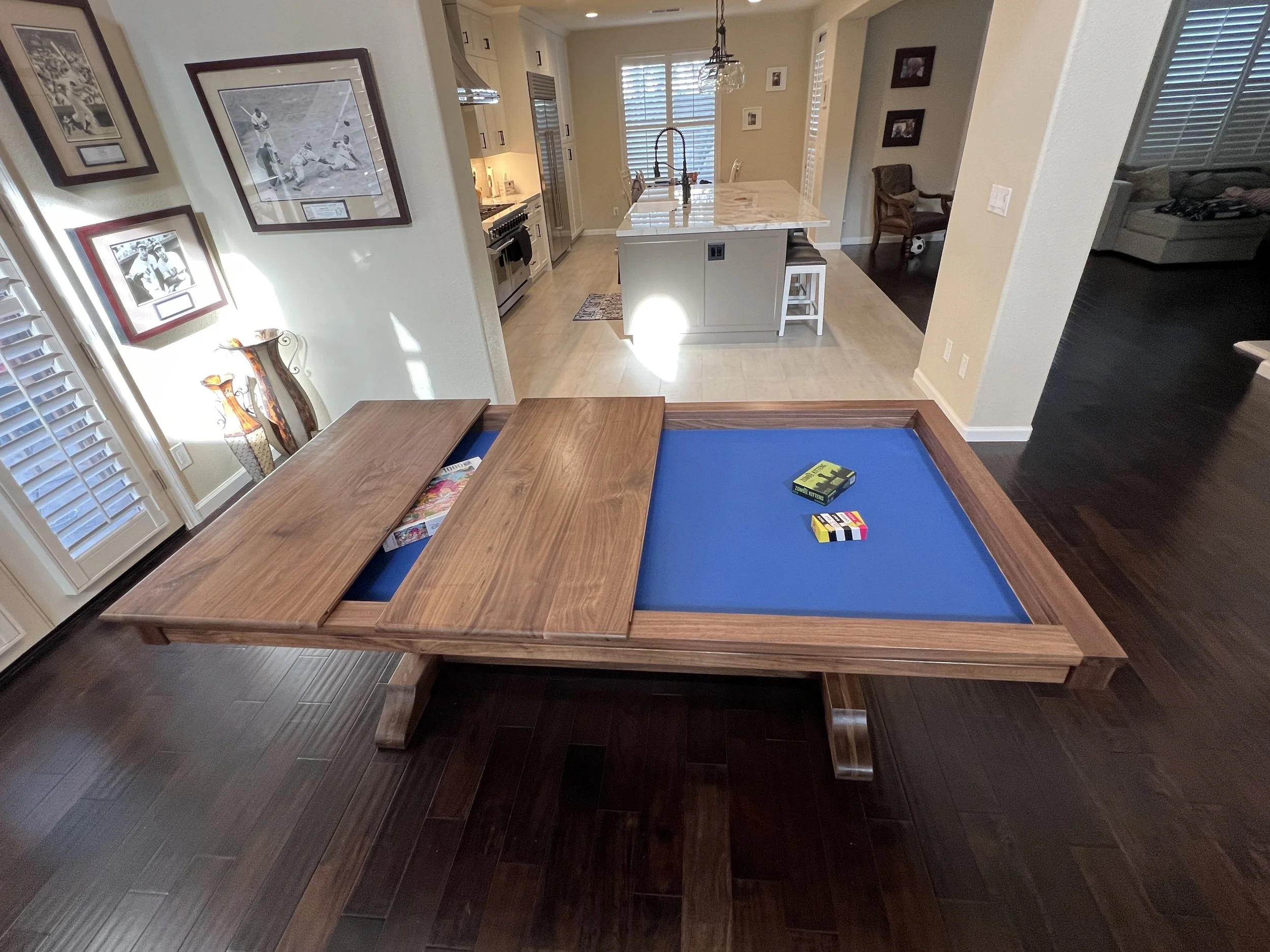 Side view of a sleek game table with 2 removable toppers placed on the top to show the ability of easy removal