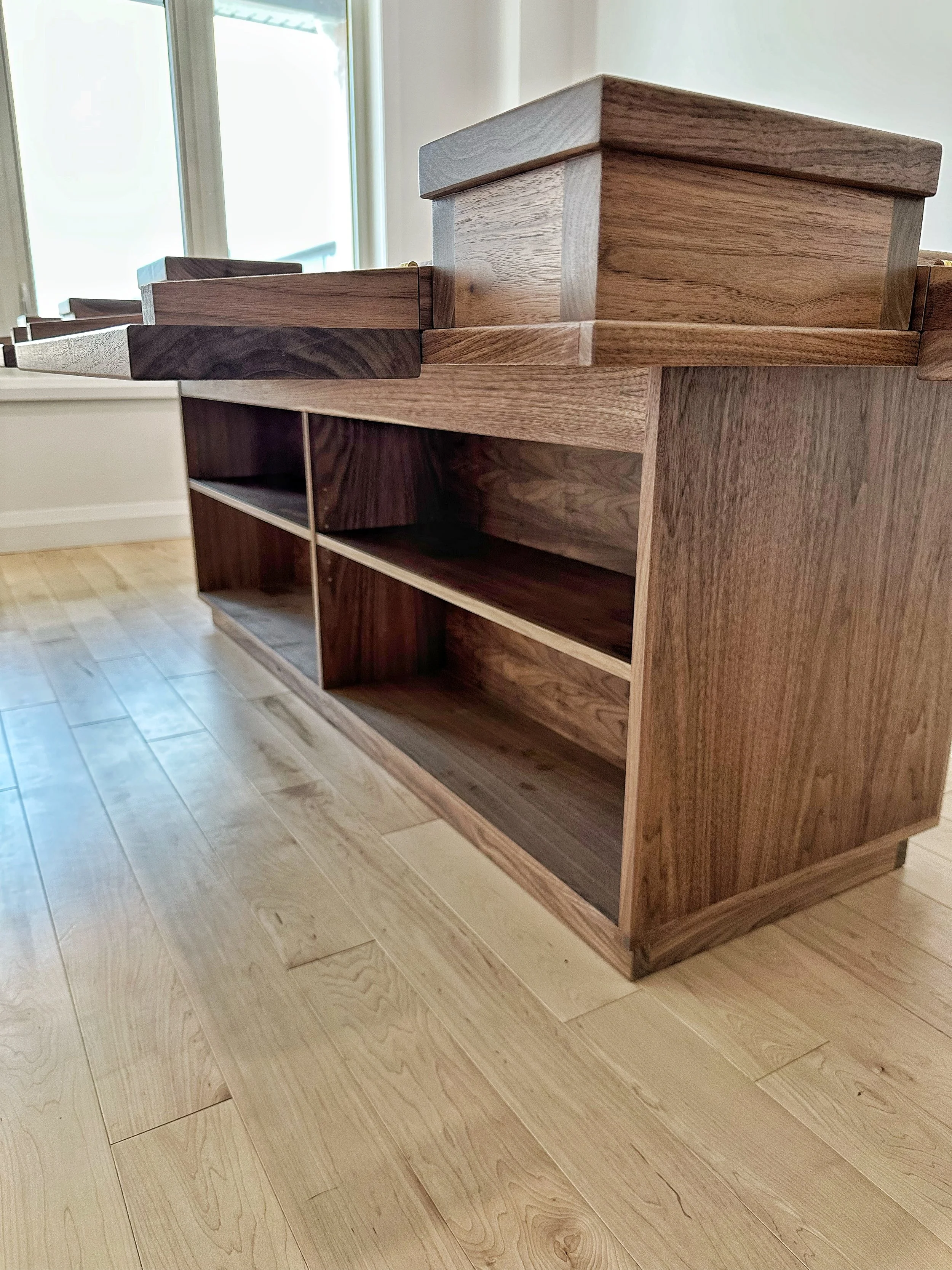 A low view of a cabinet style base for a custom player station style board game table