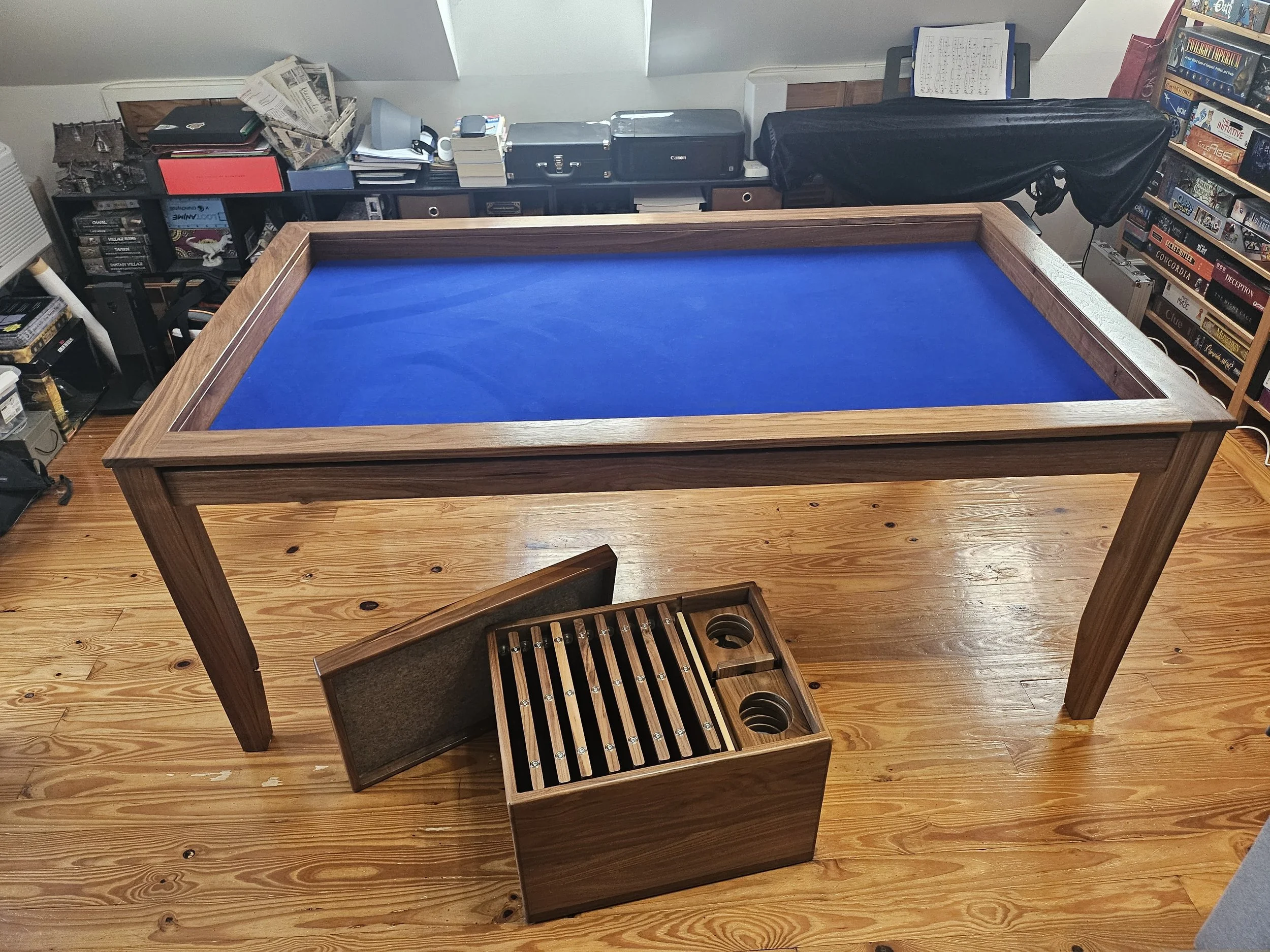 A side view of a walnut game table with a custom wooden crate holding all of the accessories for the magnetic game rail