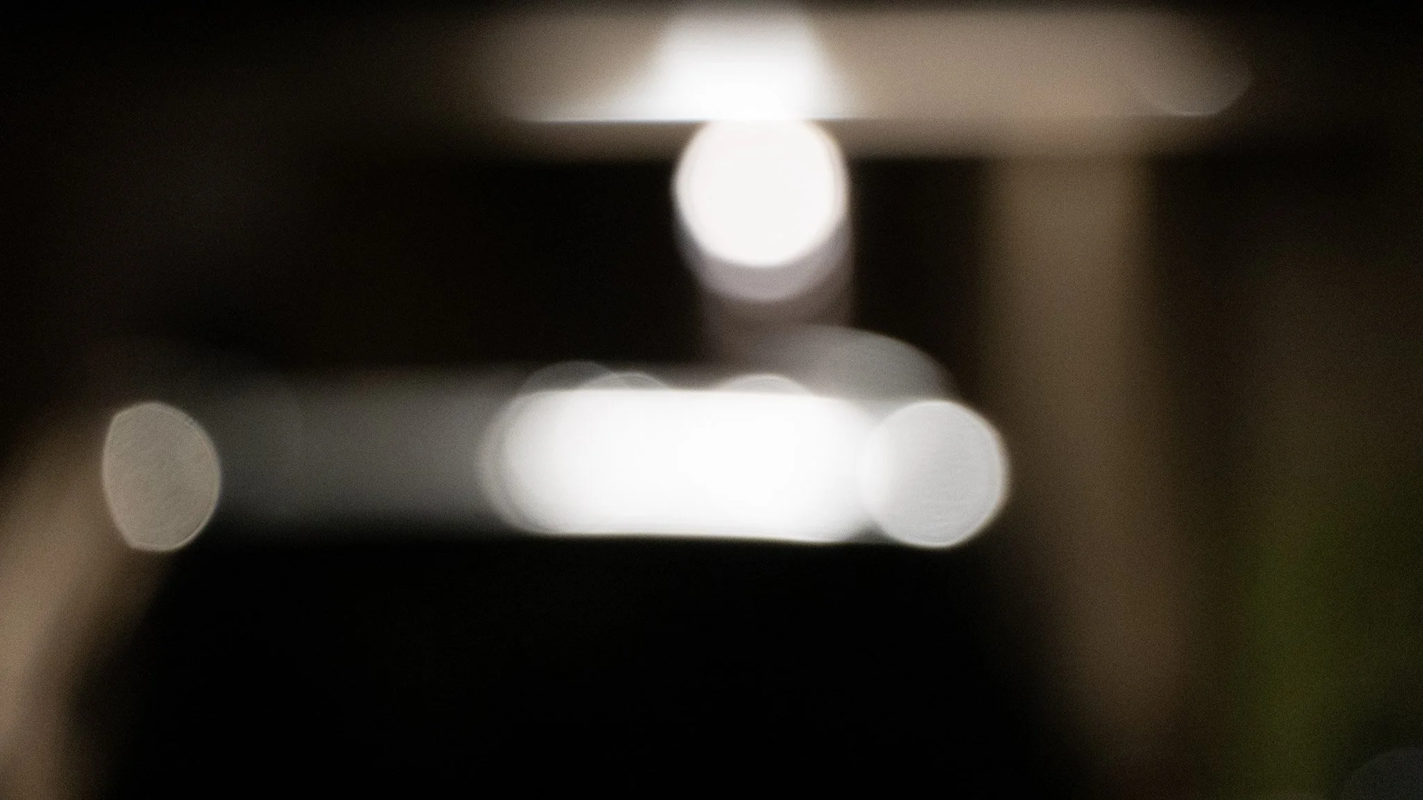 Blurred image with bright lights and bokeh effect, dark background.