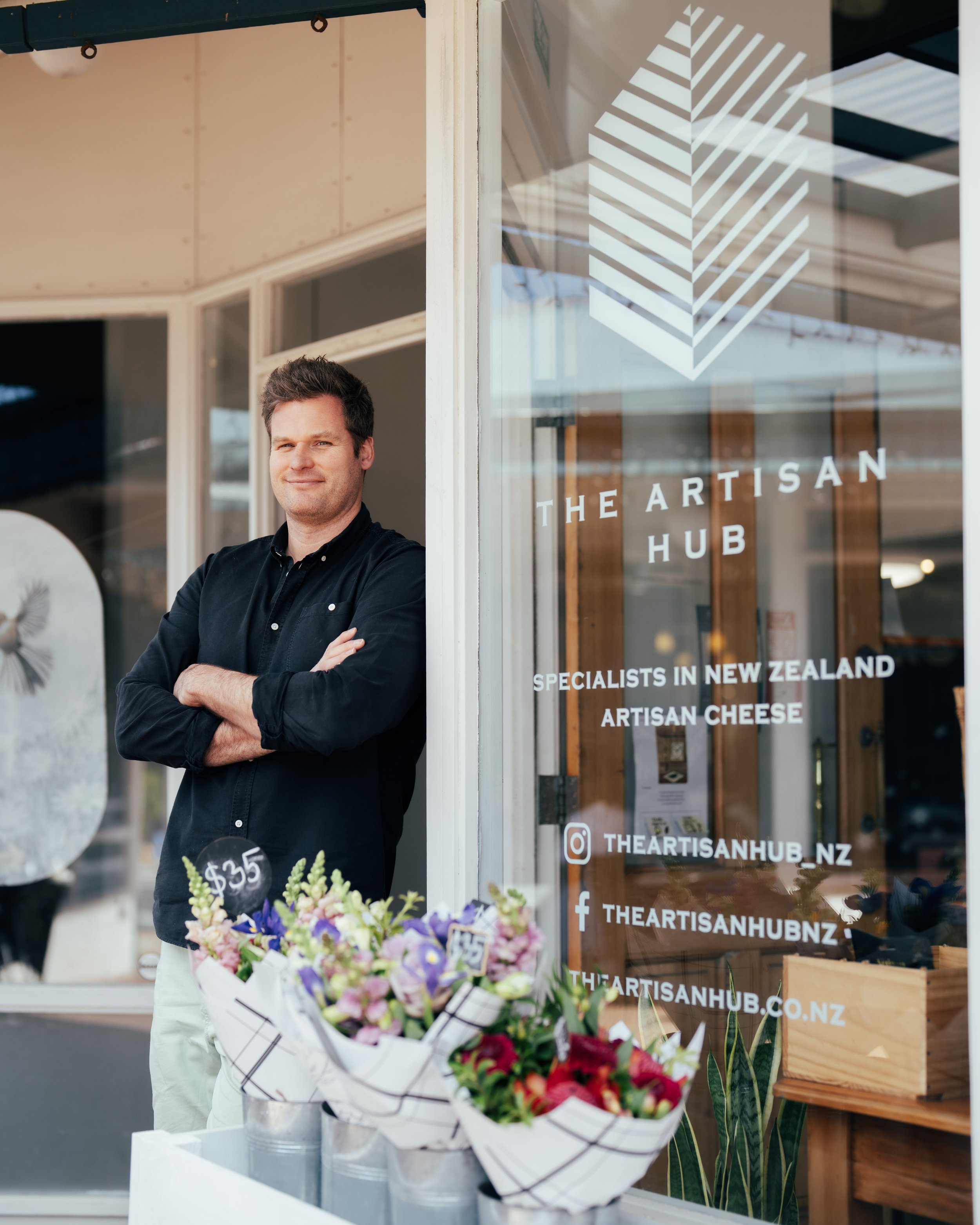 The village cheesemonger at his shop door