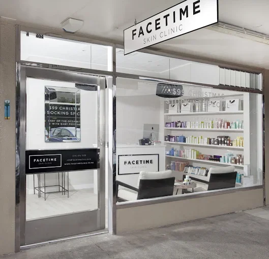 Facade Skin Clinic storefront with glass door and window, signage, interior reception area, shelves with skincare products, and seating.
