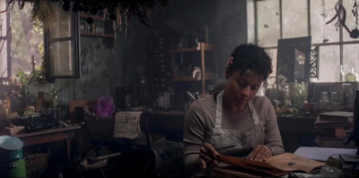 The chef is looking through the witch's book of recipes or spells.