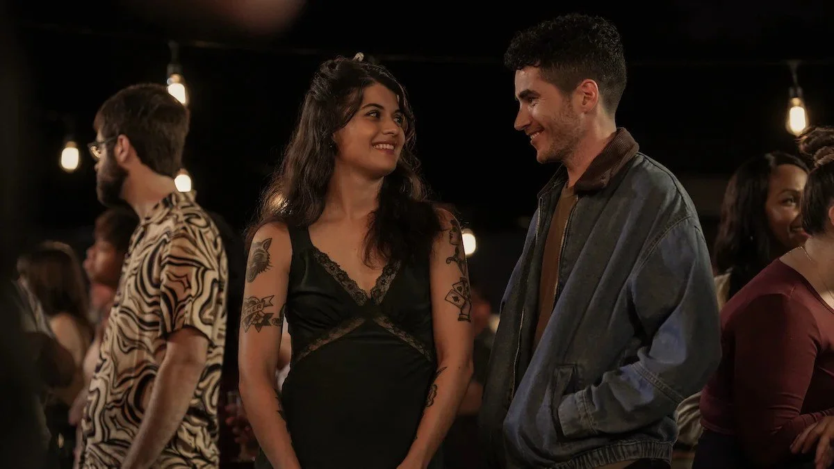 Alex and Sam are smiling at each other.