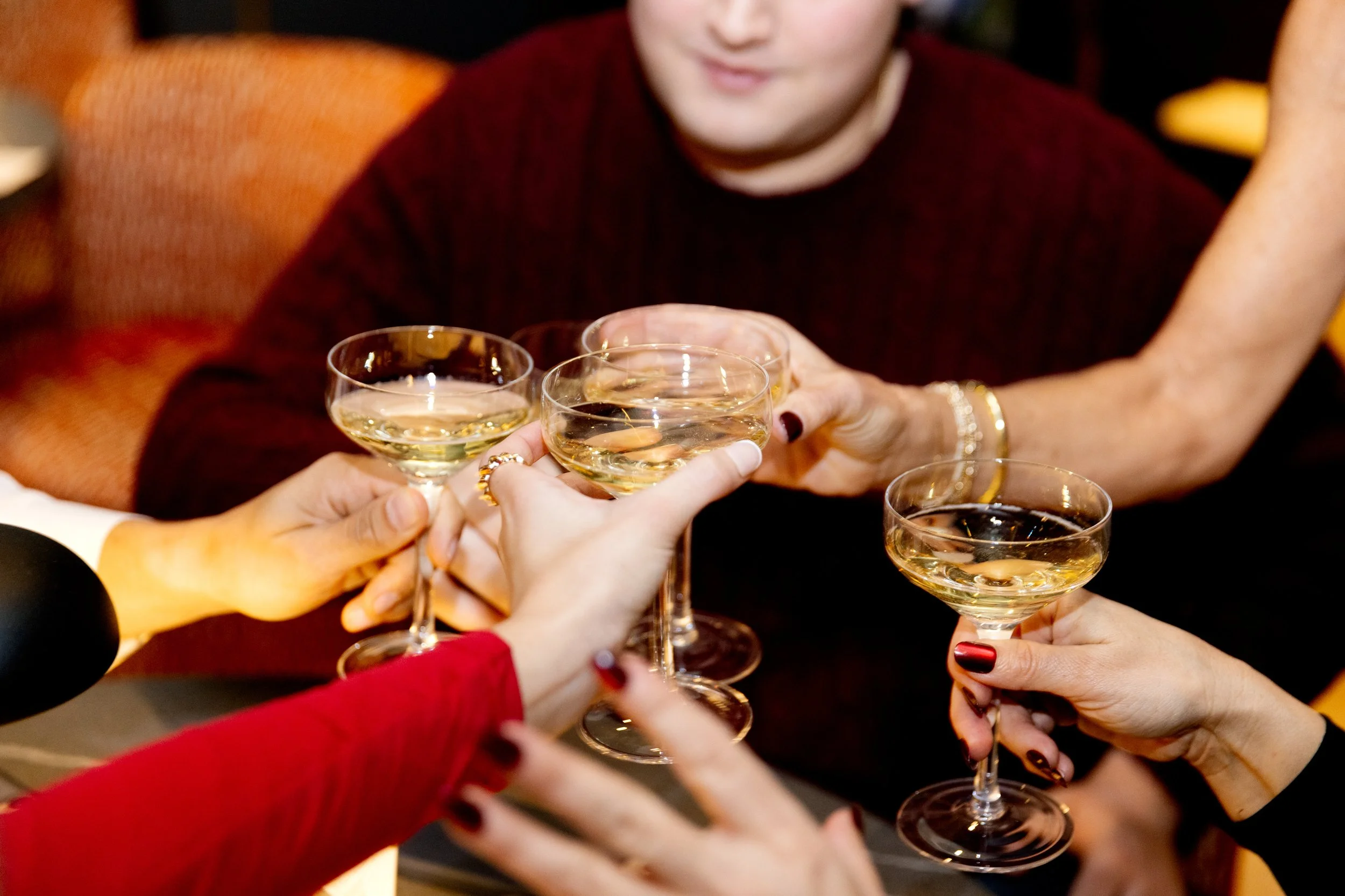 People clinking glasses filled with champagne in a celebration.