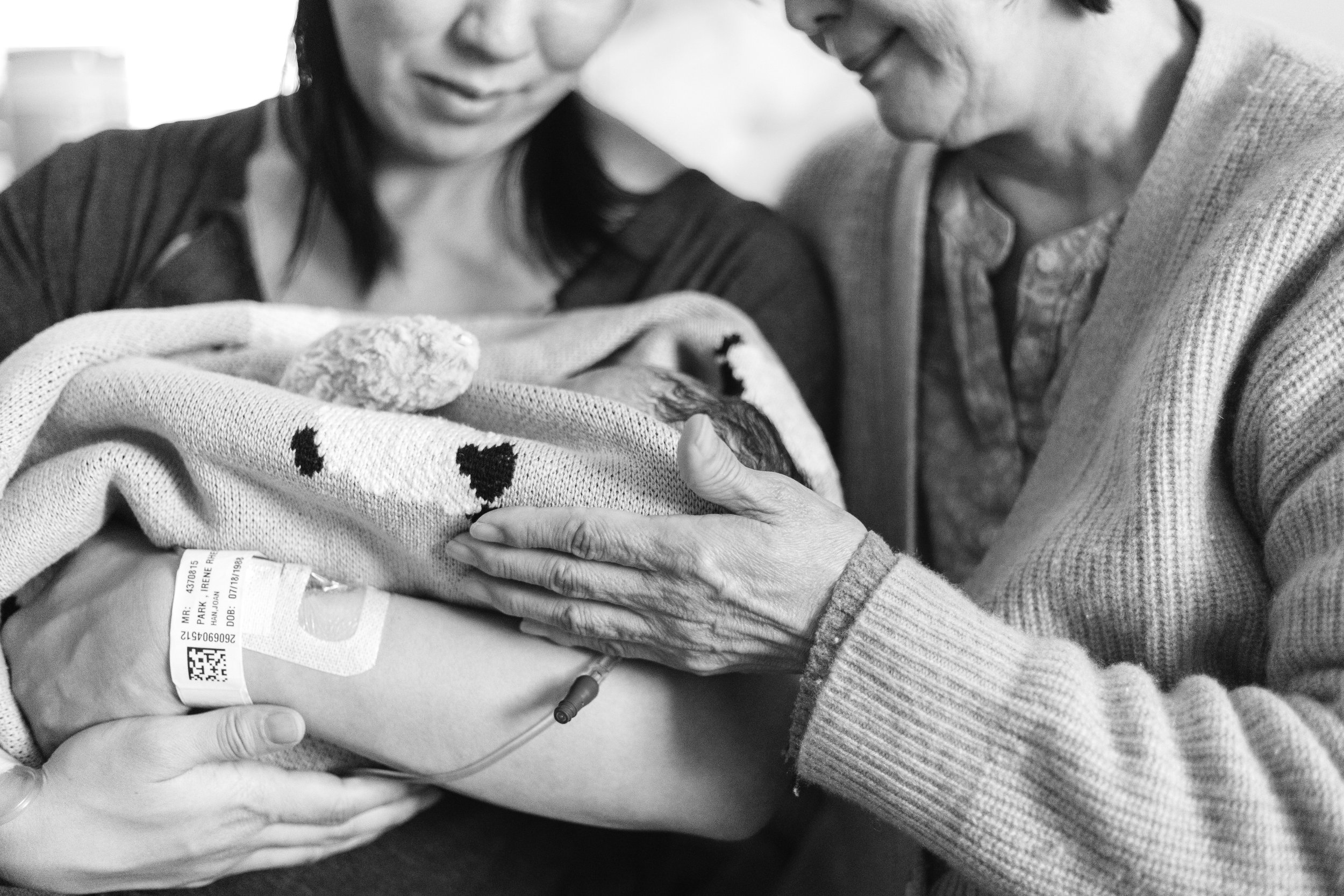 Multiple hands gently holding a child's hand, symbolizing care and support.
