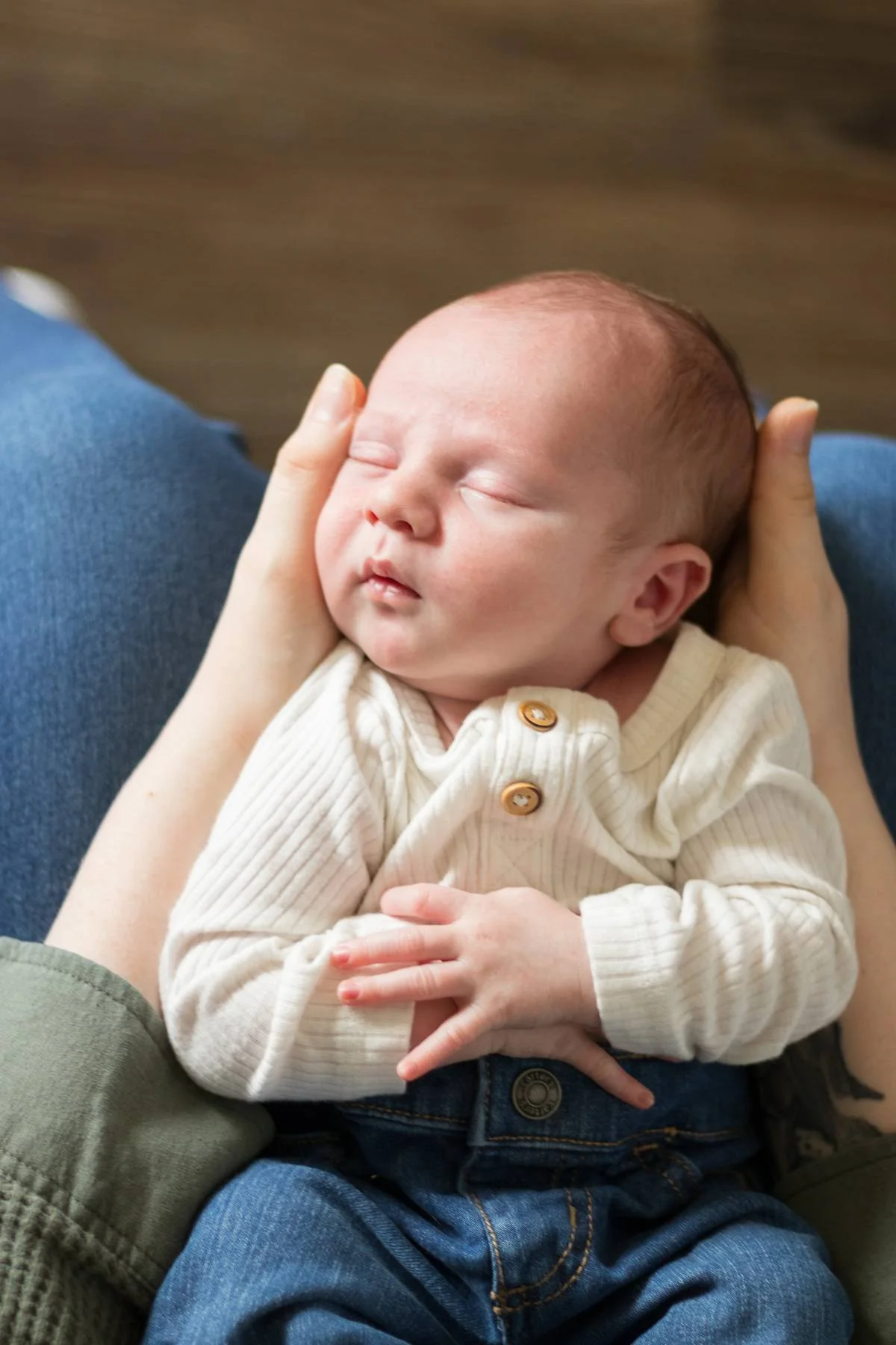 A woman with red hair gently breastfeeding a newborn baby.