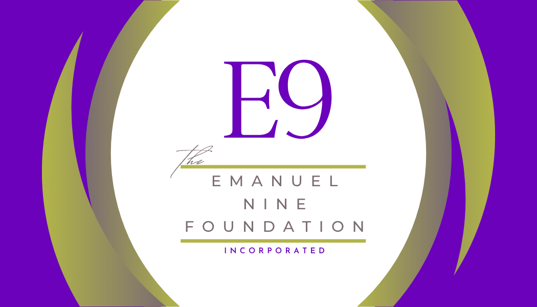 A woman with round glasses and earrings smiling in an indoor setting.