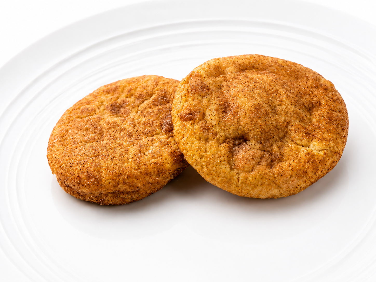 Two baked savory pies with flaky crusts on a white plate.