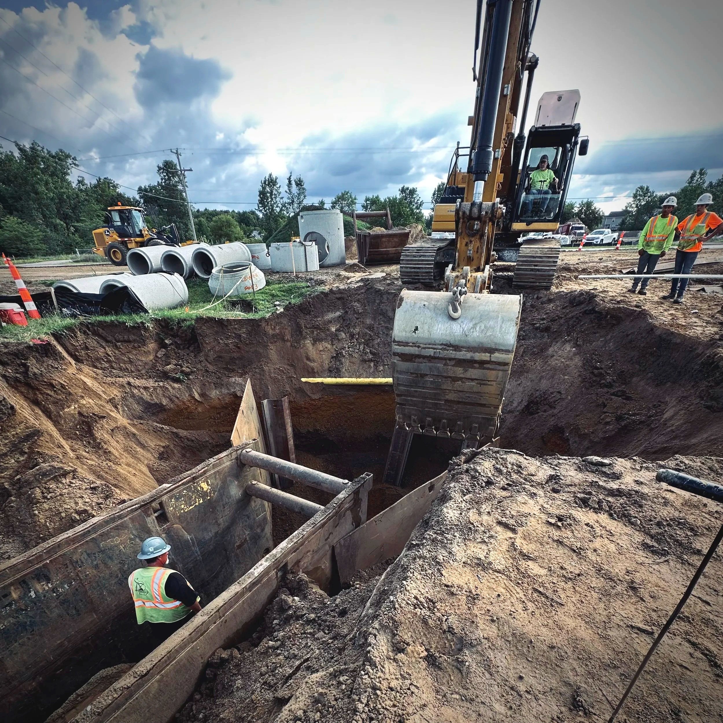 Construction site with a bulldozer on gravel and dirt, under a clear blue sky.