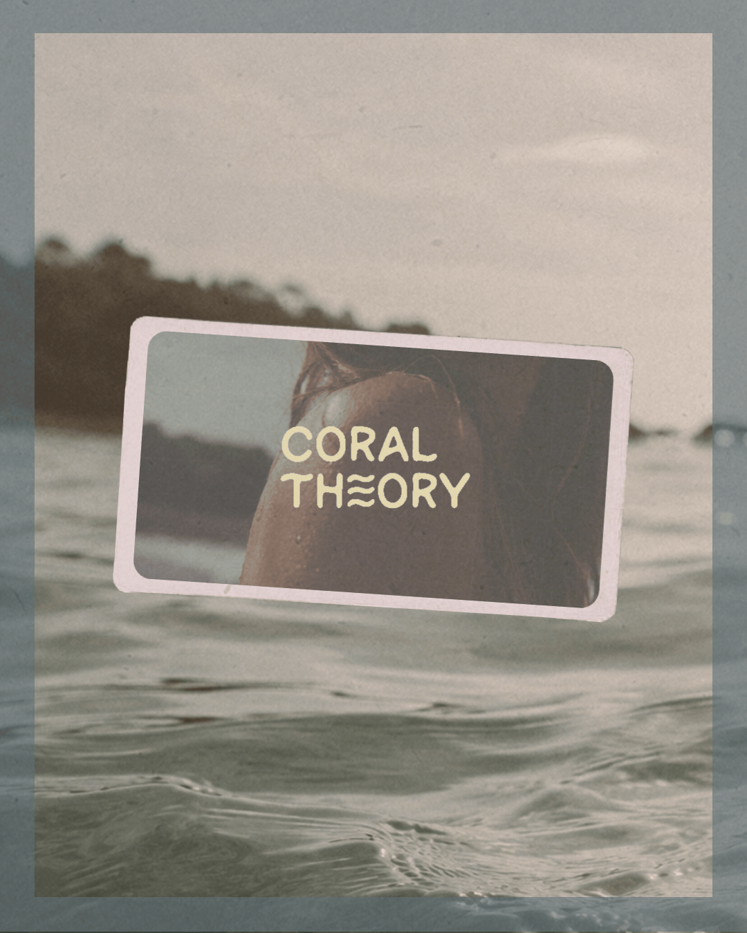 Brand Design for surfwear brand coral theory. A floating sign in the water with the words 'Coral Theory' over a background of ocean and a distant shoreline.