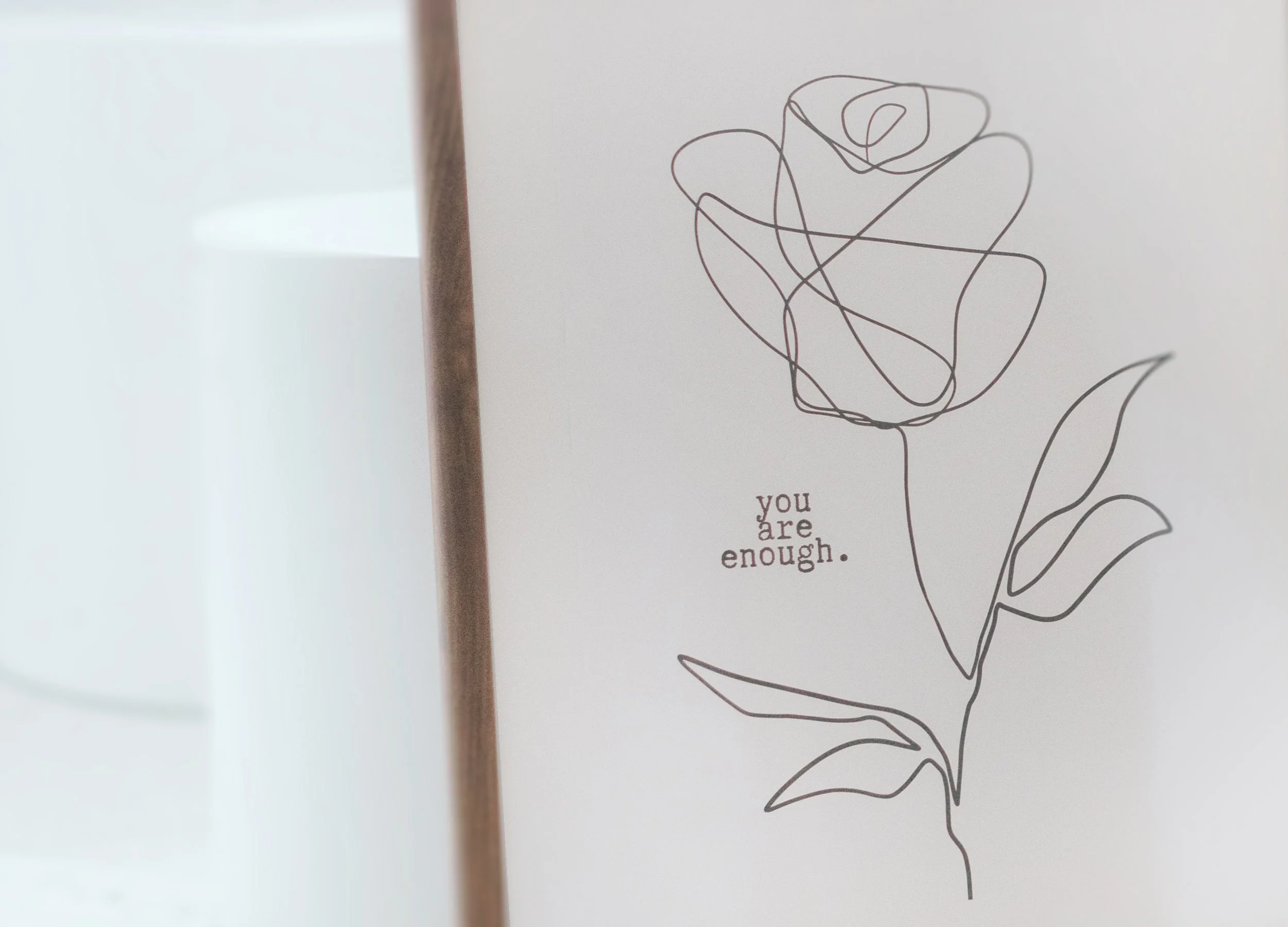 Framed line drawing of a flower with the words ‘you are enough’ beside it