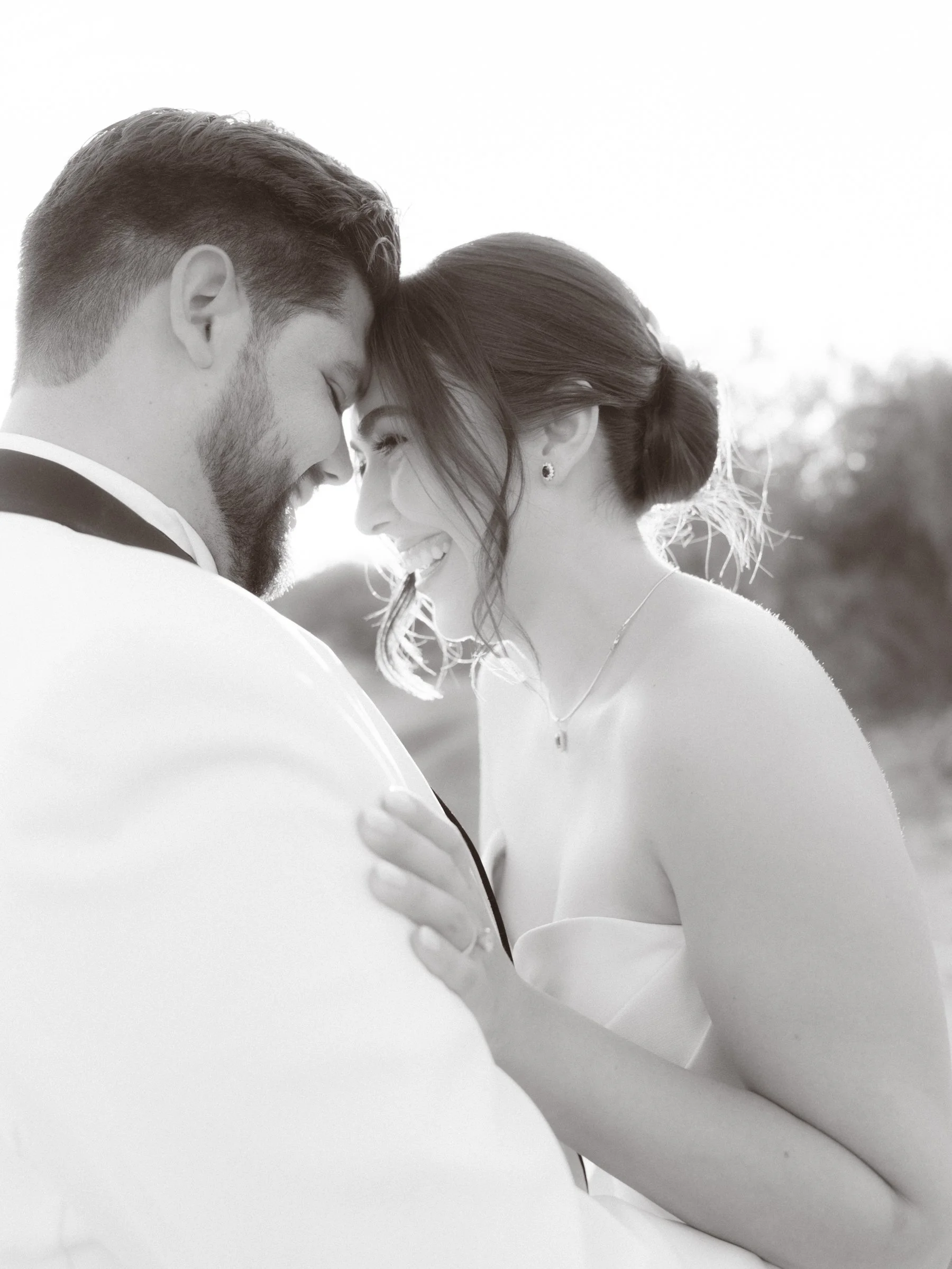 Pareja feliz en un abrazo, con la frente tocándose, en una foto en blanco y negro.