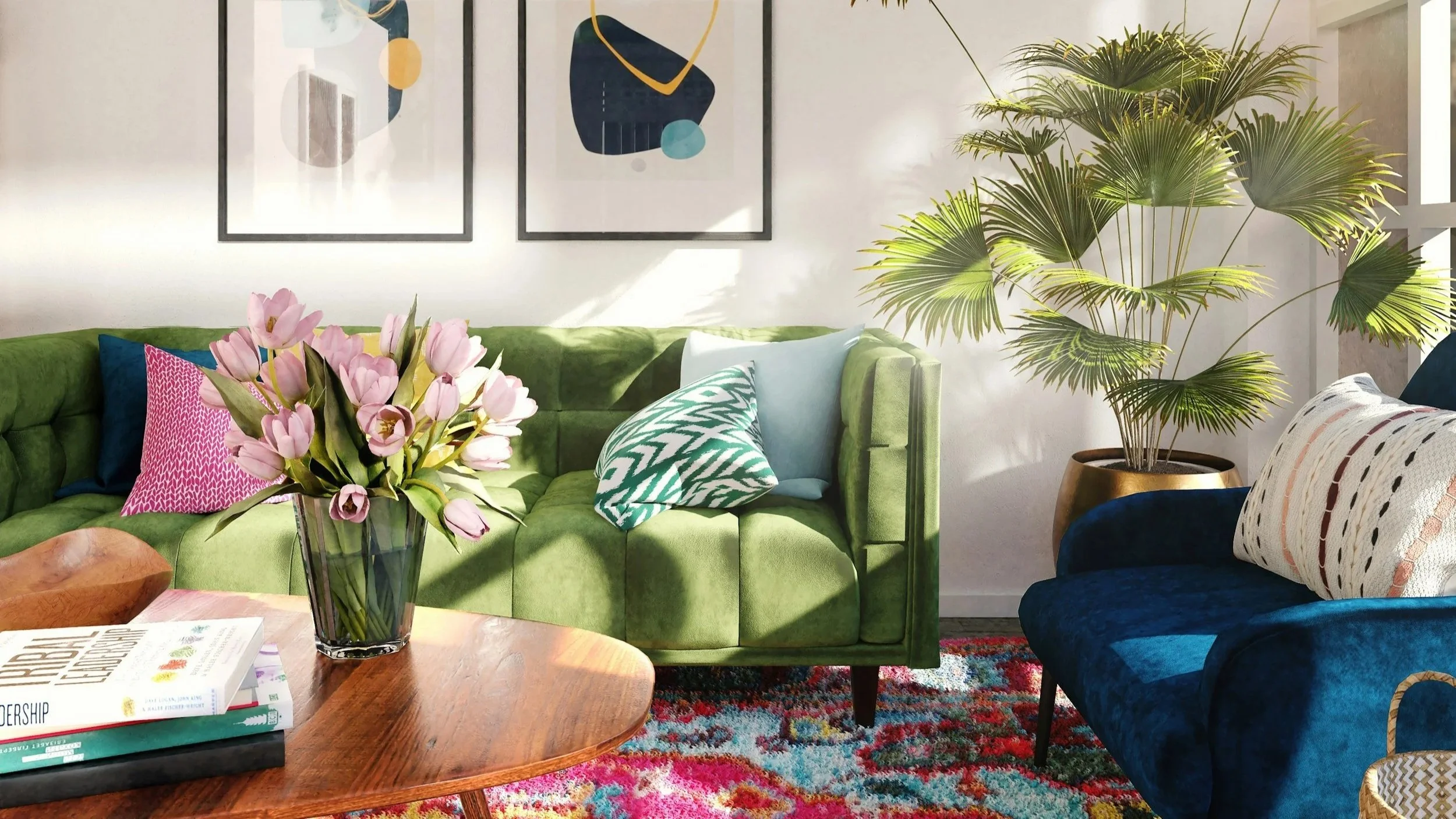 Living room with green and navy sofas, colorful pillows, hardwood coffee table with books and a vase of pink tulips, large potted palm, and cloth artwork on the wall.
