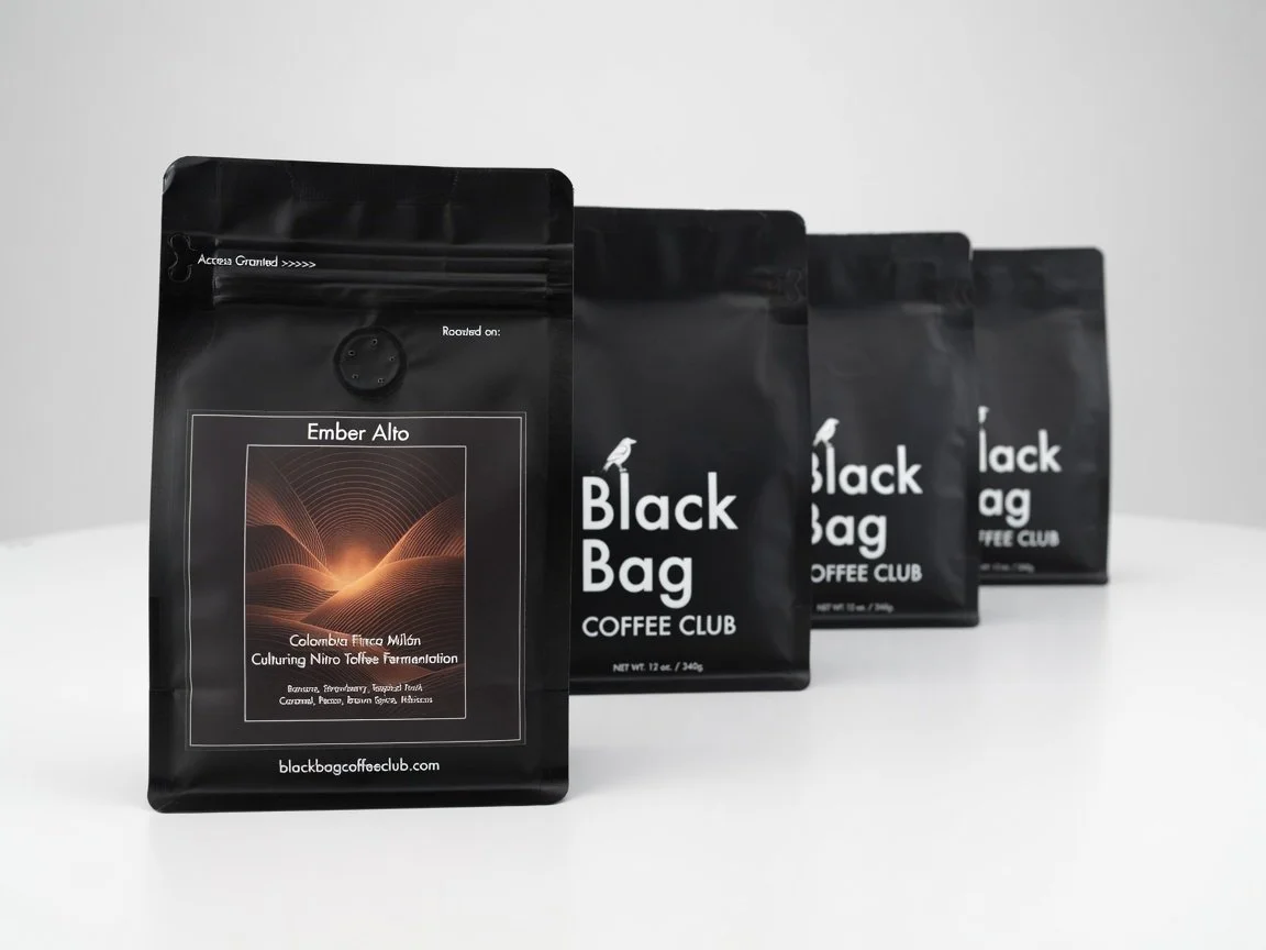A set of four assorted black bag coffee club bags lines up