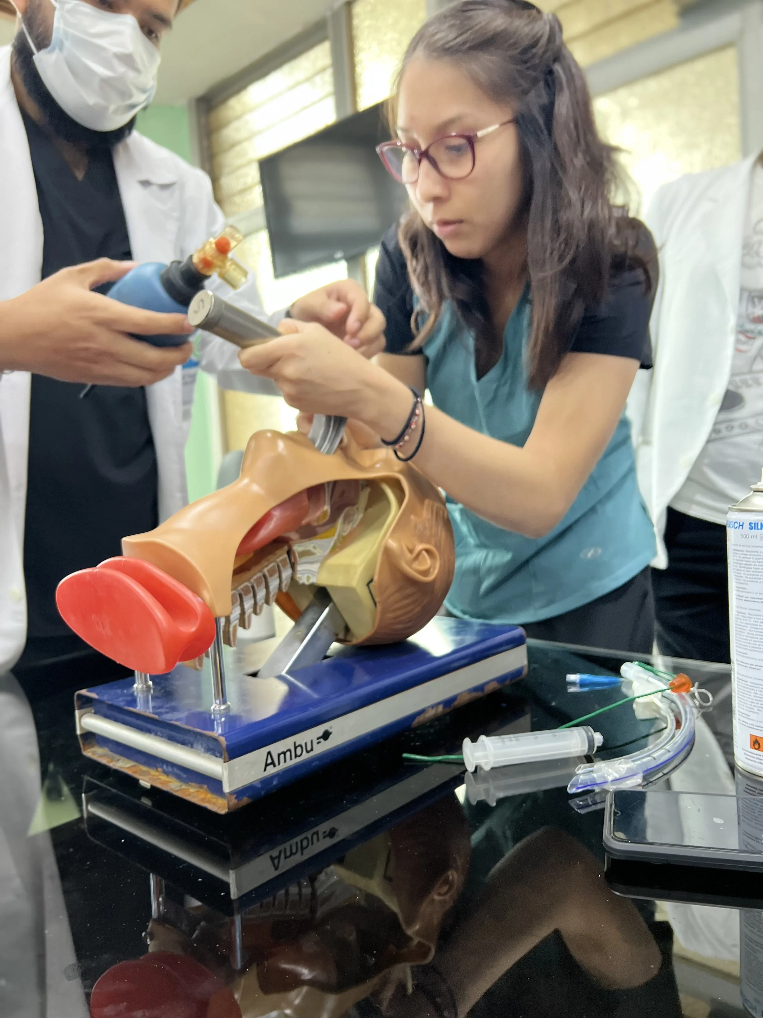 Two medical professionals, a man and a woman, examining an X-ray of a skull on a tablet in a modern medical office.