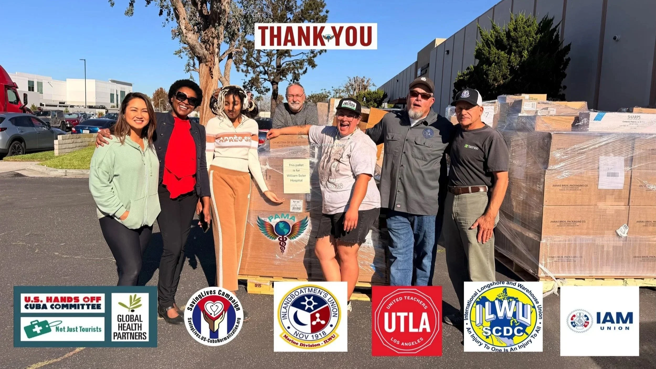 Group of eight diverse people standing outside in a parking lot, smiling and posing for the photo, with large stacks of cardboard boxes wrapped in plastic behind them and a "Thank You" sign overhead. Various labor union logos and messages are displayed at the bottom of the image.