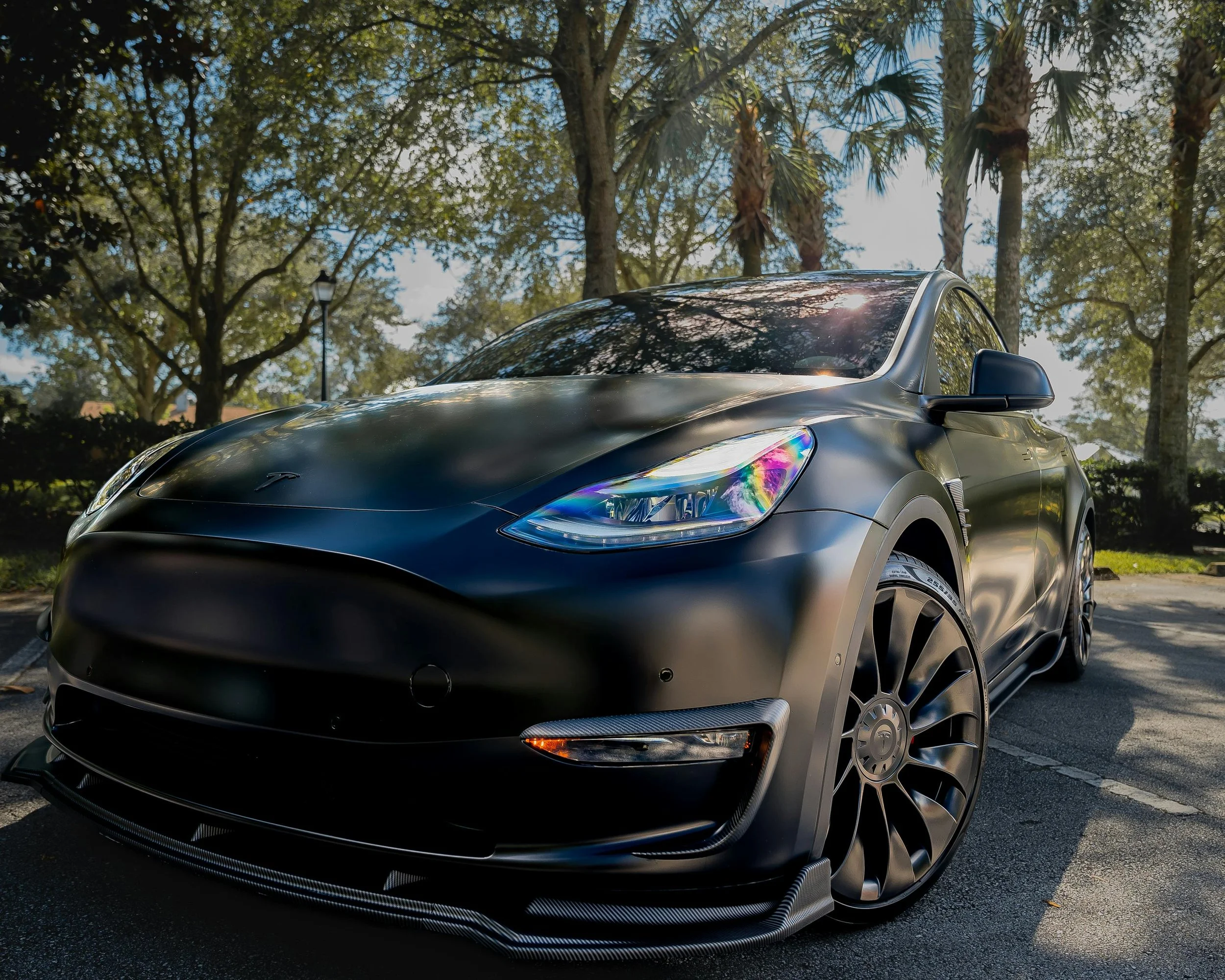 Matte black Tesla with detailed wheels and exterior finish after luxury car detailing.
