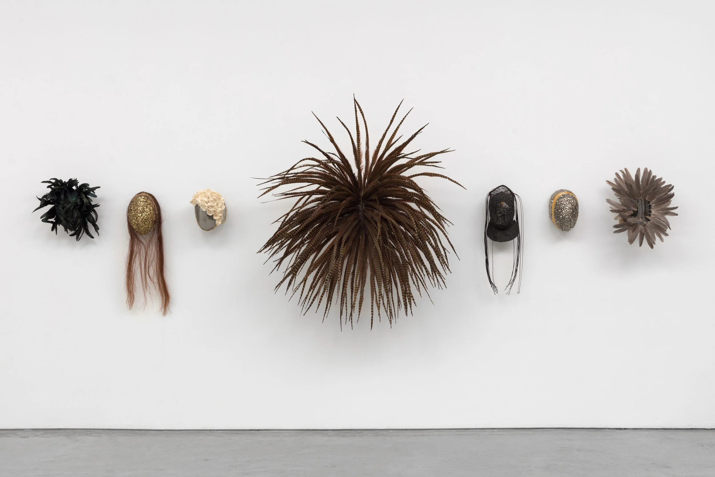  Seven Champions of Peculiar Engagement , 2020 
Vintage metal and leather fencing masks, rooster feathers, pheasant feathers, guinea fowl feathers, vintage, marble grapes, sola wood, horse hair, metal, resin