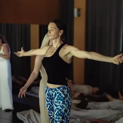 Women practicing energy work indoors on mats with eyes closed in a peaceful setting.