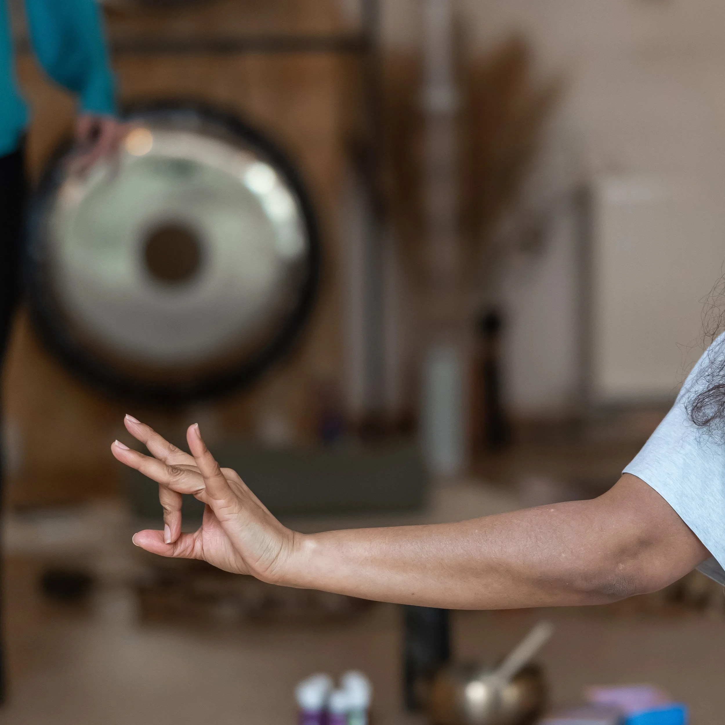 A hand doing a mudra gong on the background in a calm studio