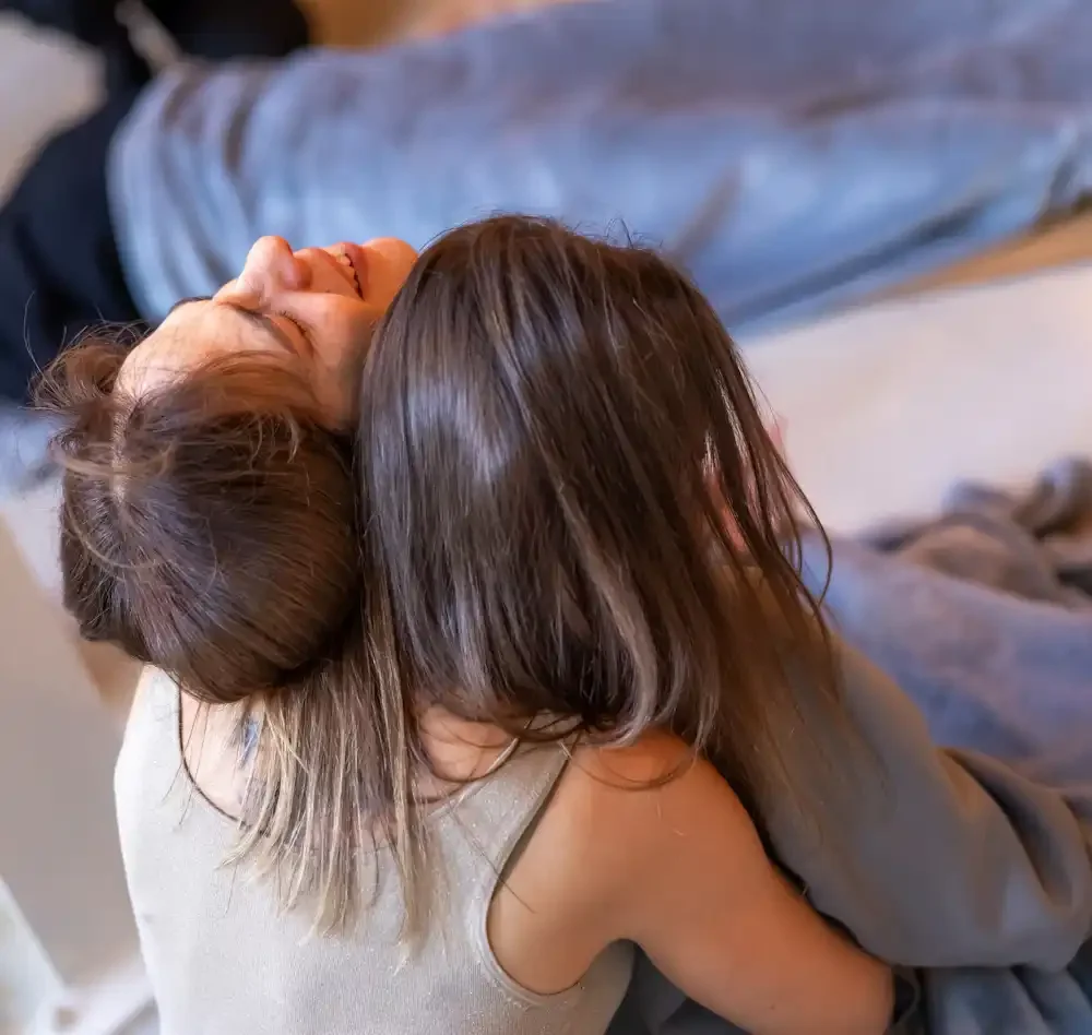 One woman is crying and being safely held by another woman in a vey loving manner