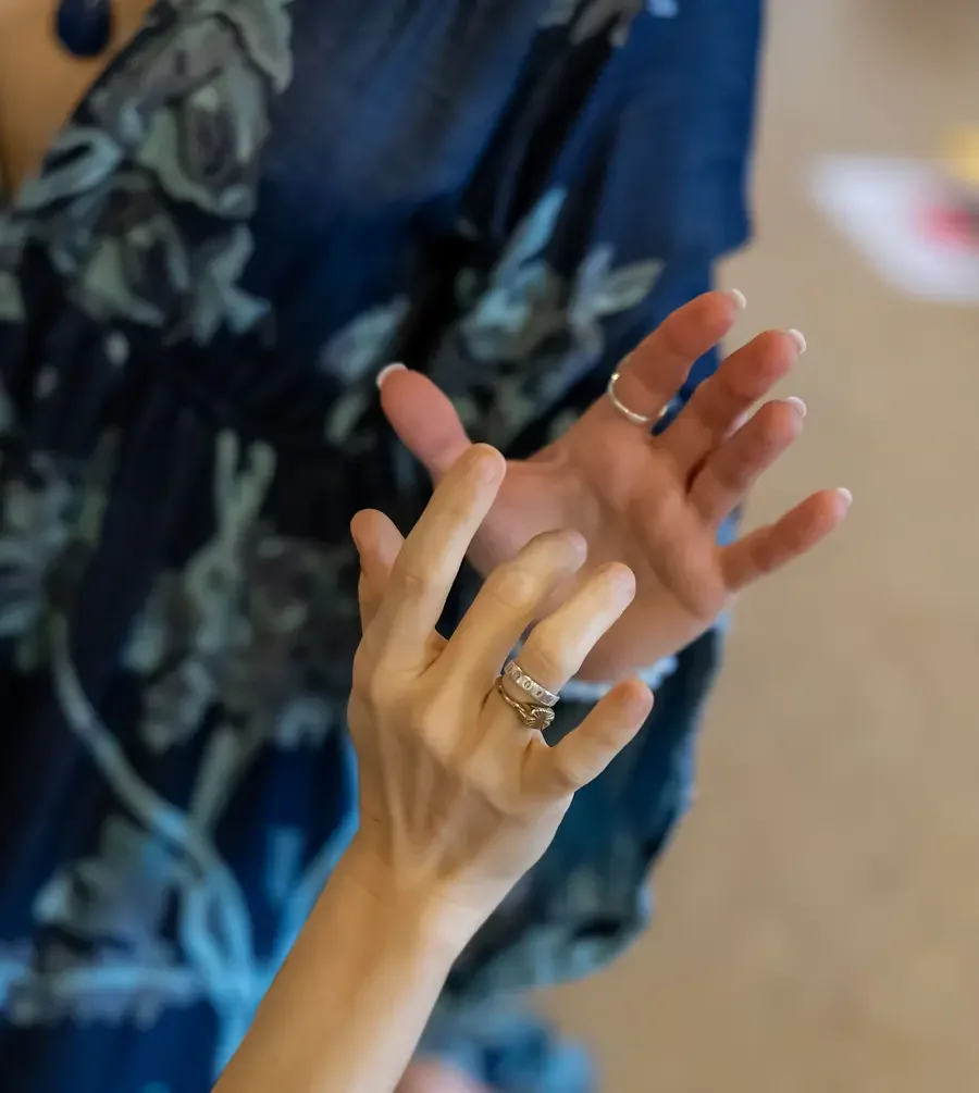 Two hands next to each other mirroring each other in a gentle movement.