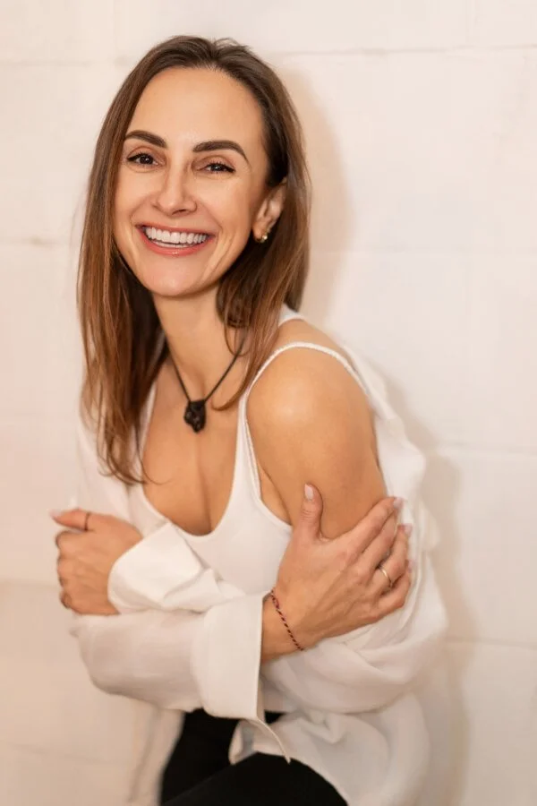 Woman is looking straight at the camera and smiling.