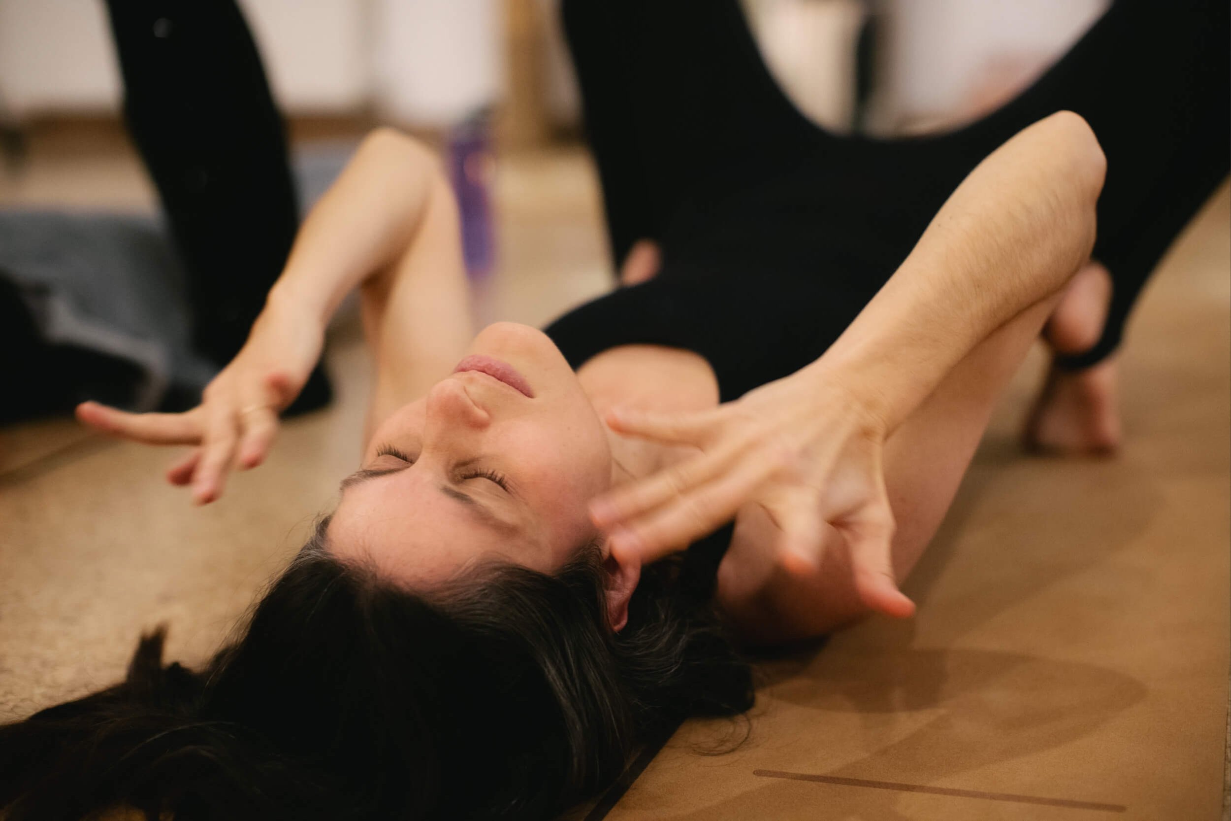 woman in a bliss state on a cork flooring during an energy session in luv yourself space.