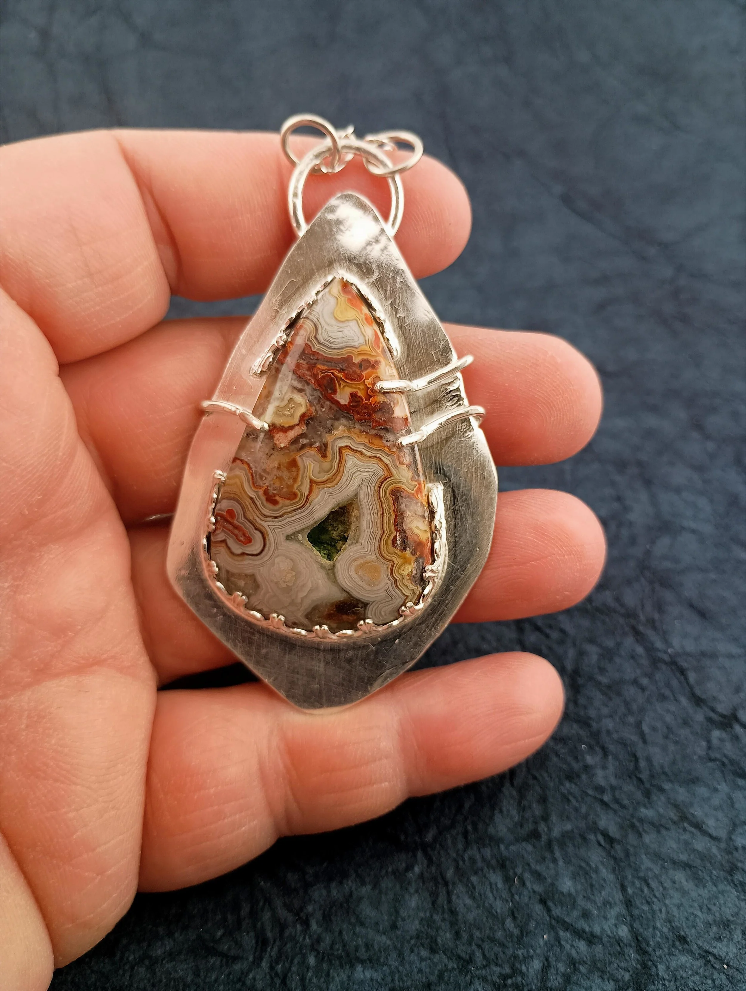 crazy lace agate in hand black background.JPG