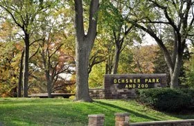 Ochsner Park and Zoo entrance sign with trees and greenery in the background.