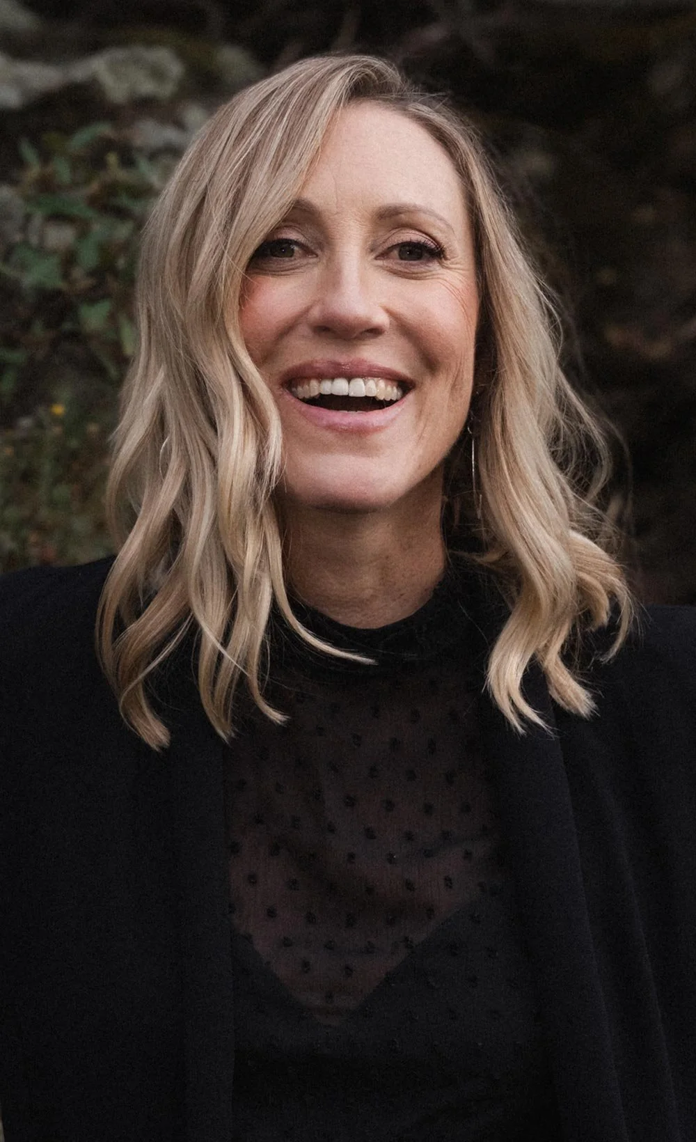 Rachel Neylan wearing a black top with a sheer, polka-dotted neckline.