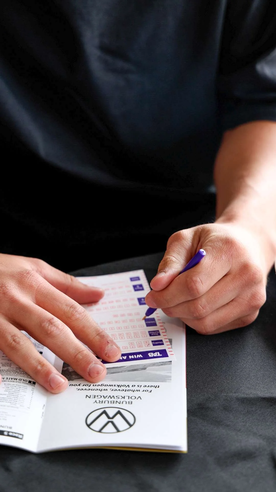 A person filling out a TAB Touch betting ticket.