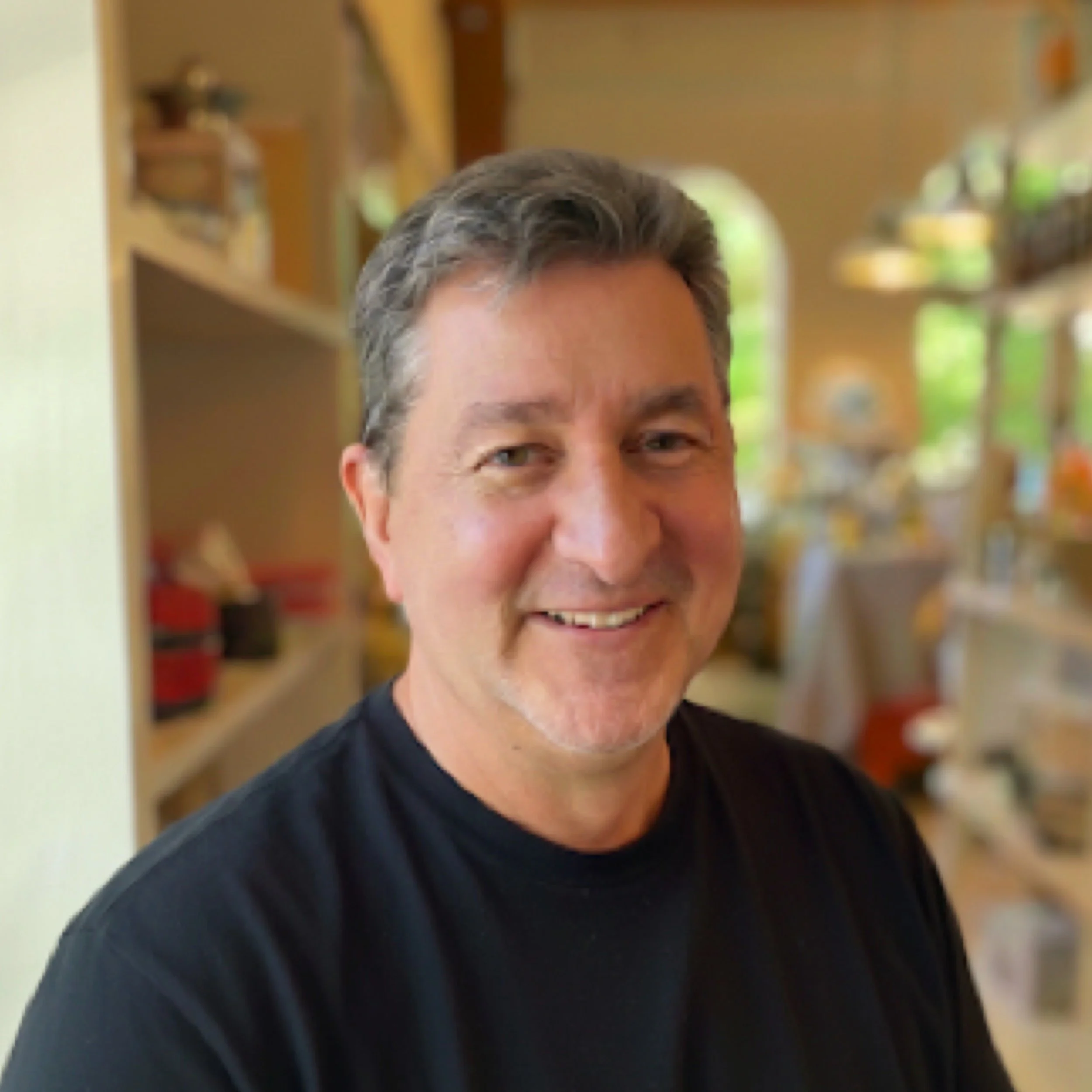 Brad Hackley sitting inside a coffee shop smiling.