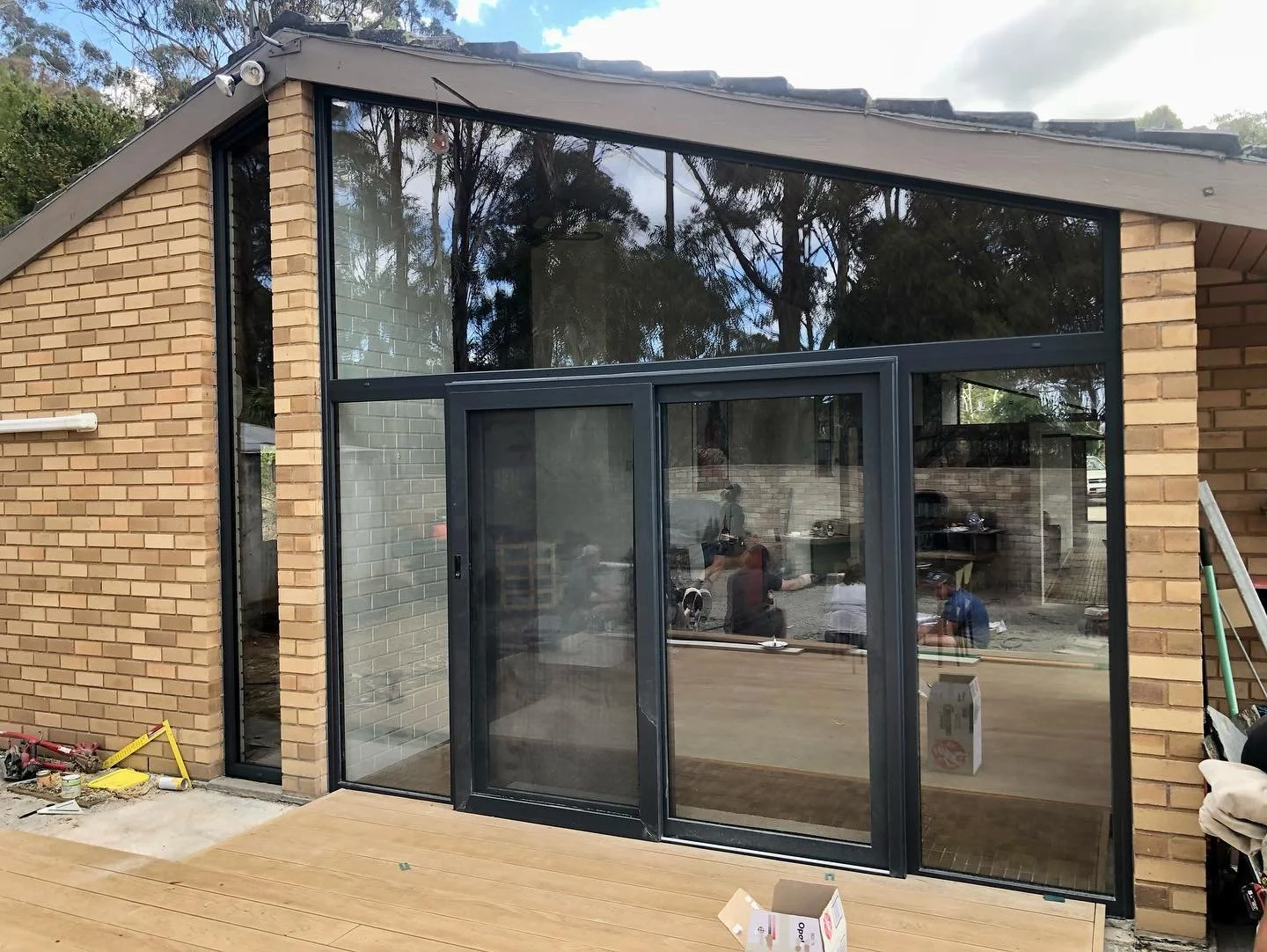 Soaring raked Windows and a VarioSliding Door system, all in Jett Black Matt uPVC frames.
