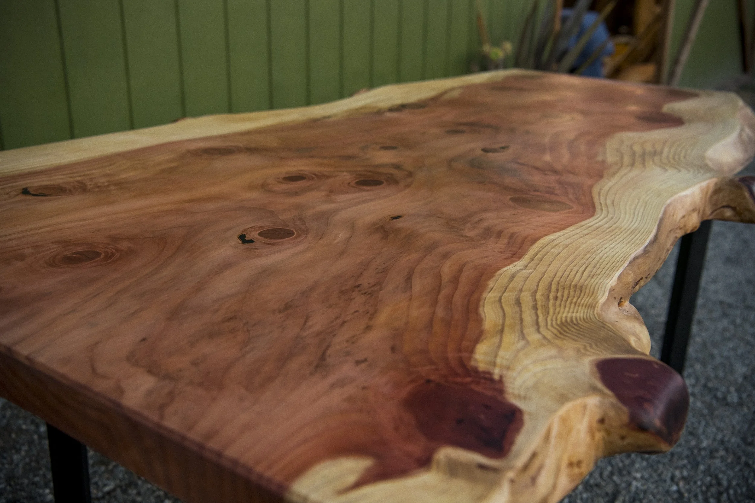 Close-up of a handcrafted wooden table with natural edges and wood grain patterns.