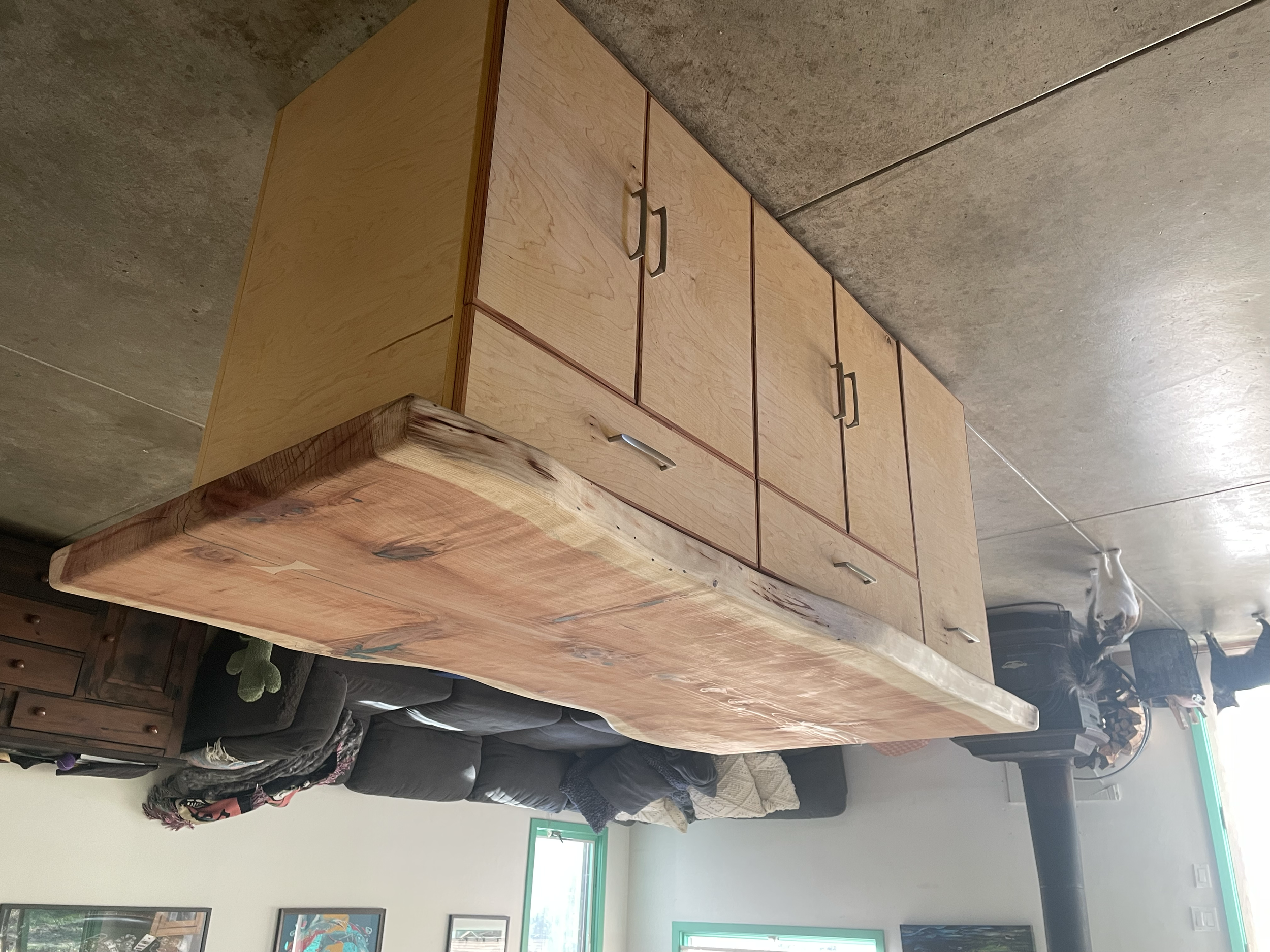 Wooden kitchen island with cabinets, drawers, and a live edge countertop in a cozy kitchen.