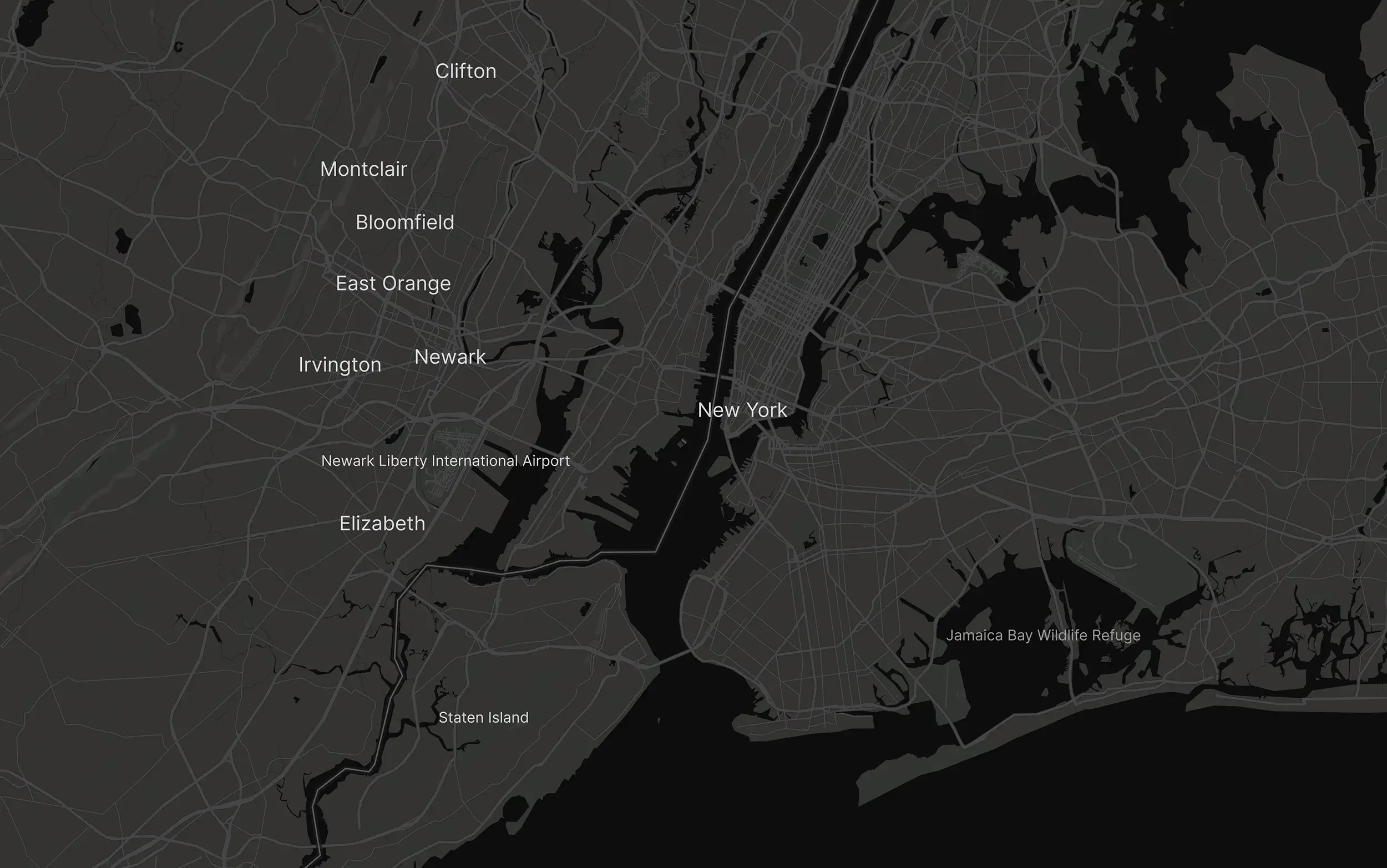 Dark map of New York City and surrounding areas showing boroughs, neighborhoods, and landmarks like Staten Island, Elizabeth, Newark, and Newark Liberty International Airport with water bodies and streets outlined.